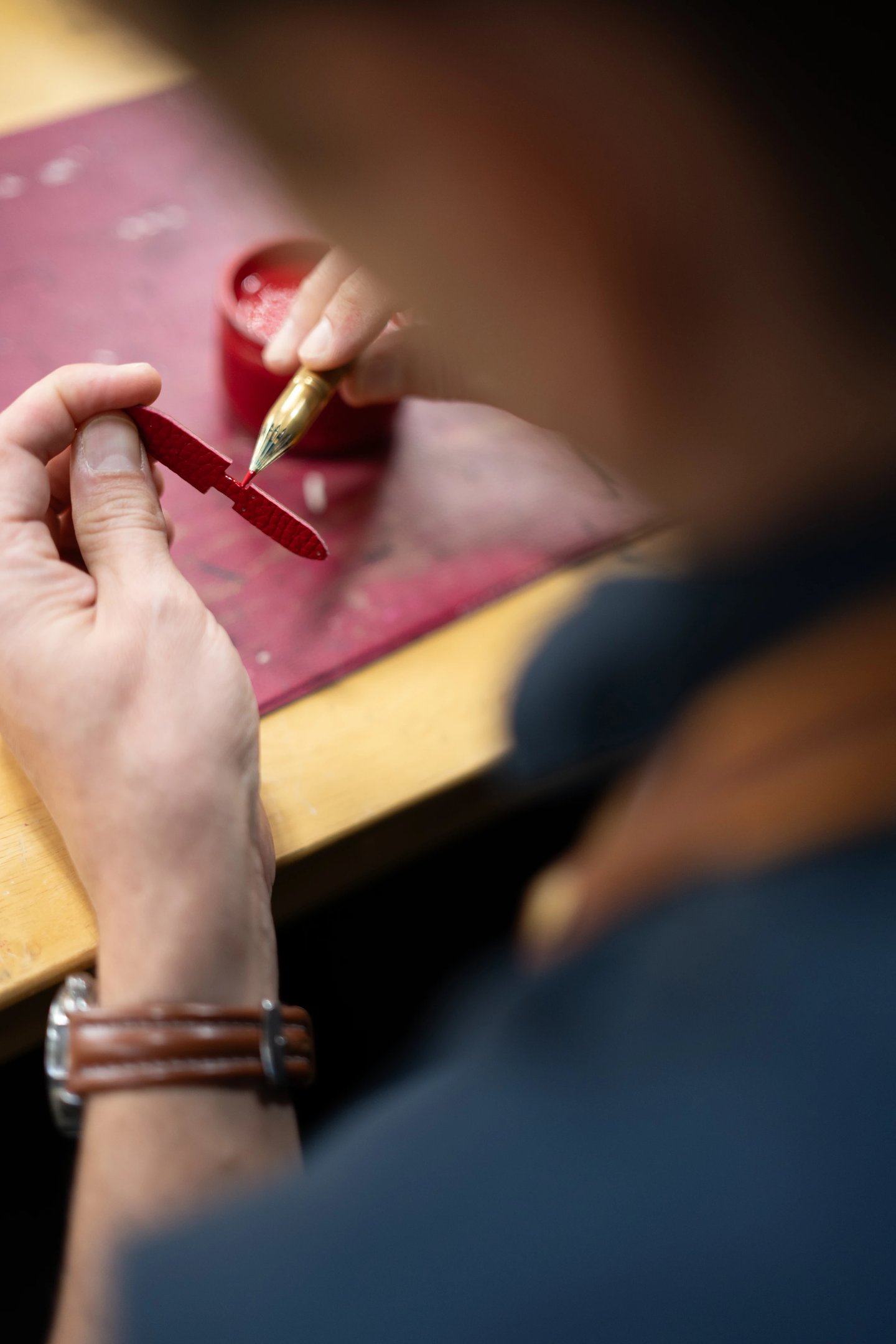 Application à la main de teinture sur la tranche d'une tirette en cuir