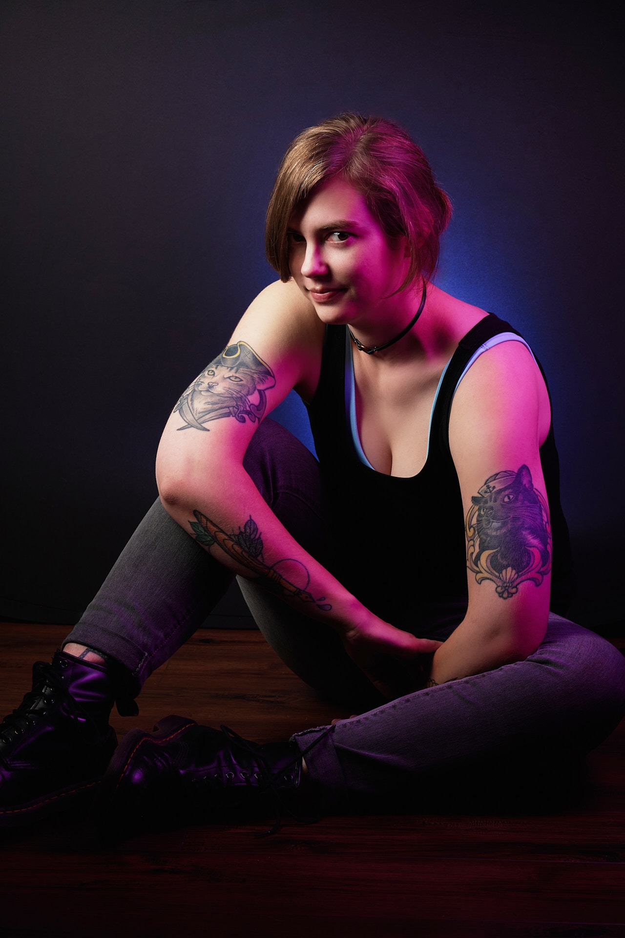 a woman with pirate cat tattoos on her arms in pink color indoor lighting