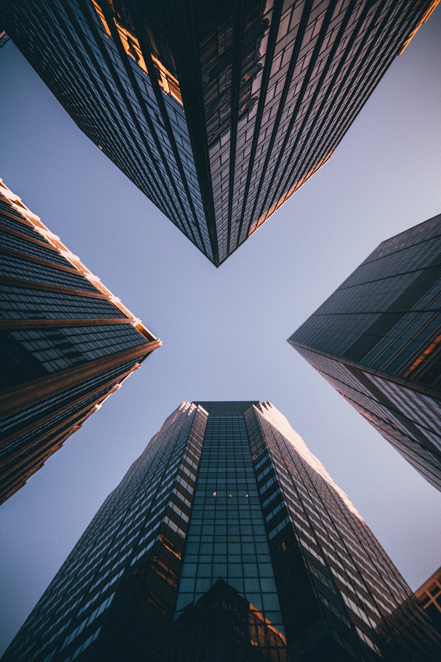 Photograph of a towering office building with blue sky above