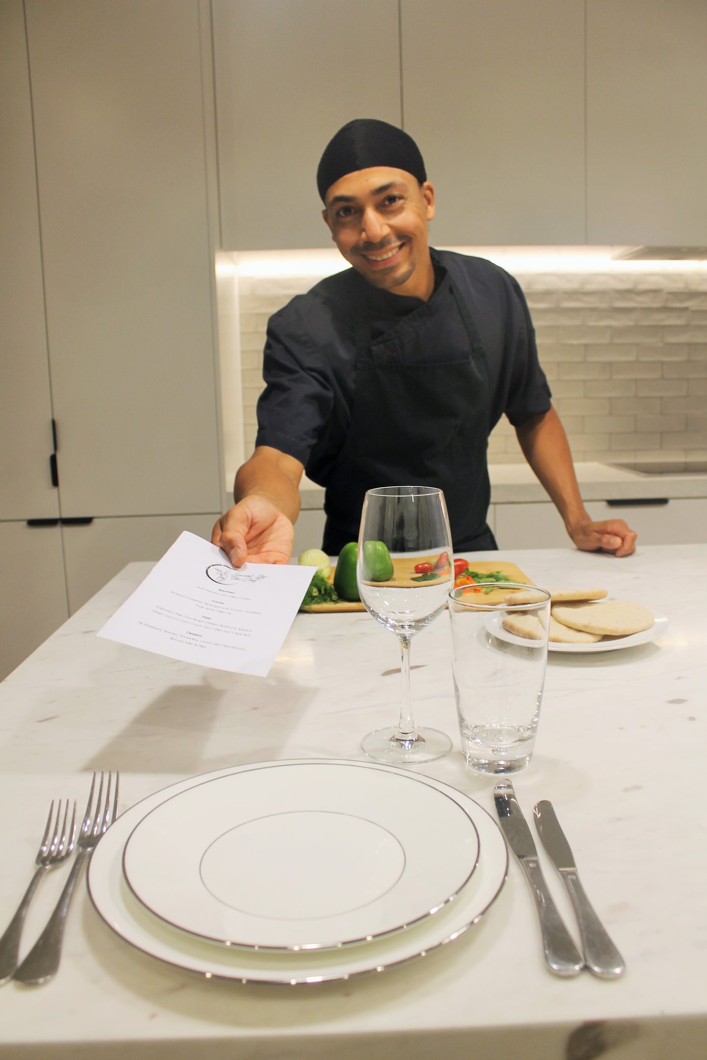 a man in a chef's uniform is holding a piece of paper