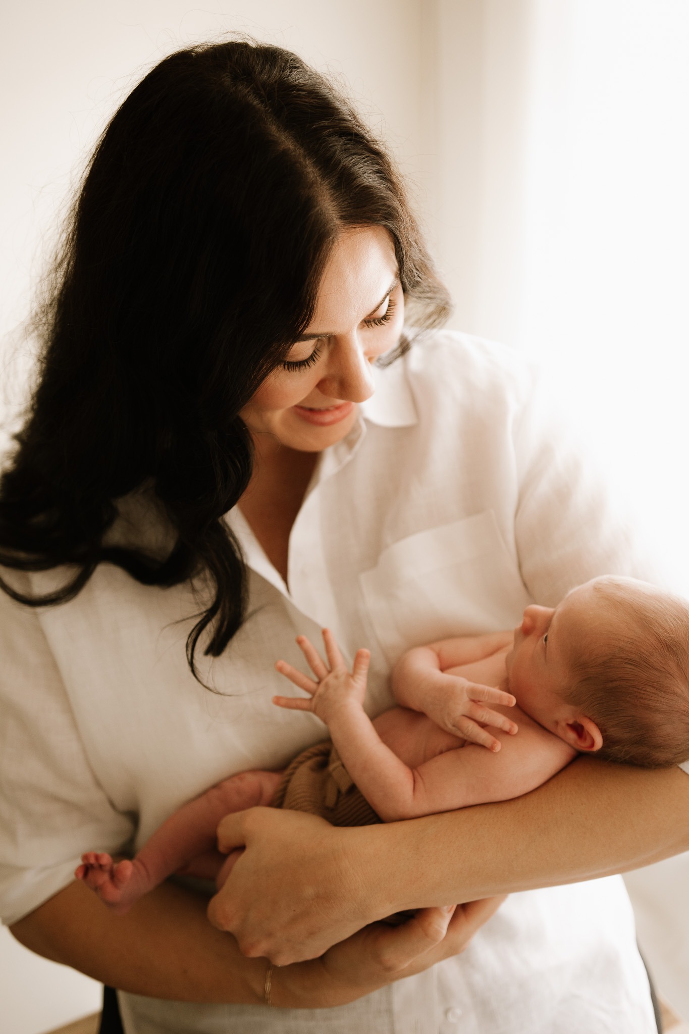 Tender moment between baby and parents, part of a newborn lifestyle photography session in Adelaide