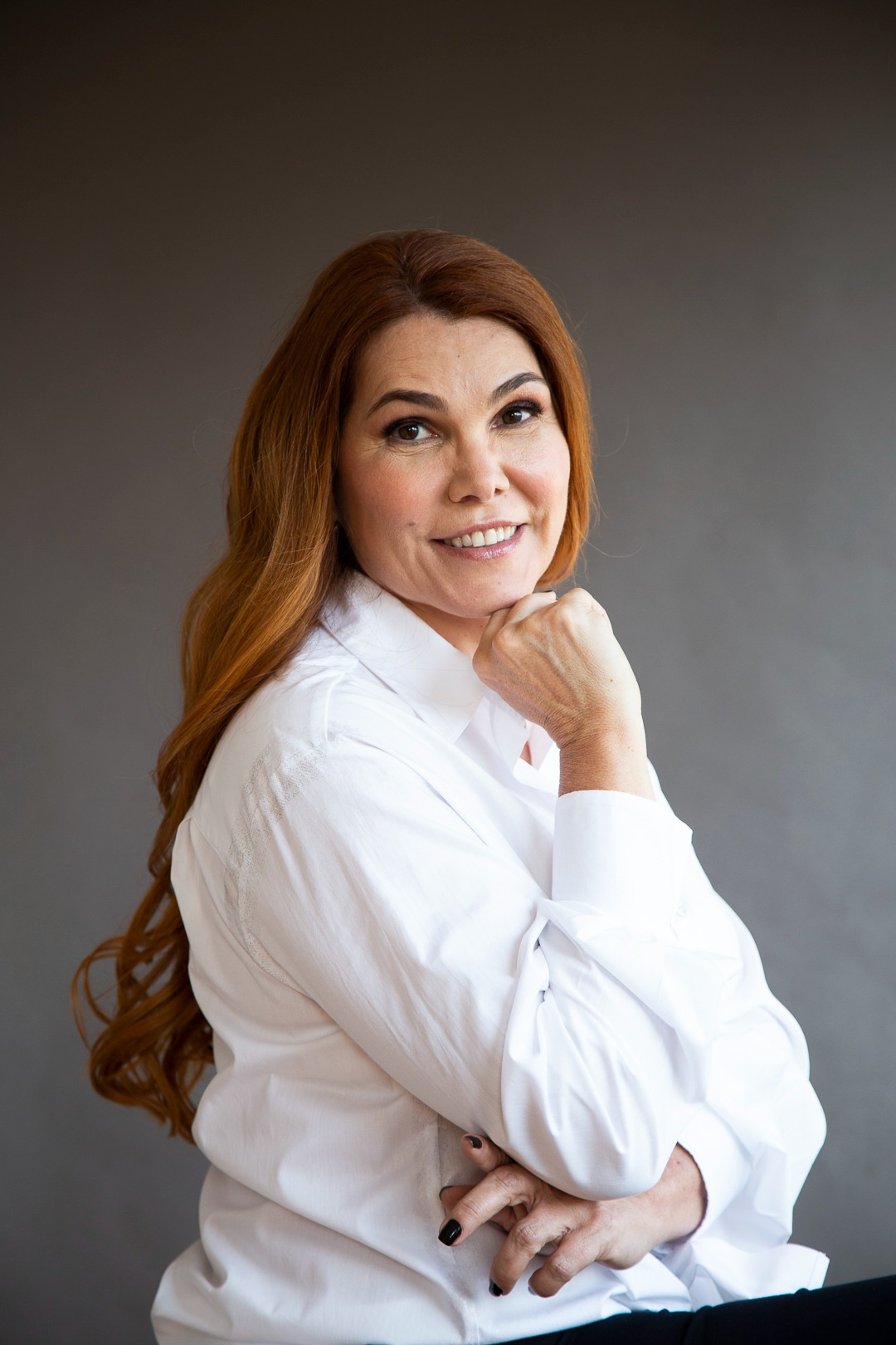 a woman with red hair and a white shirt