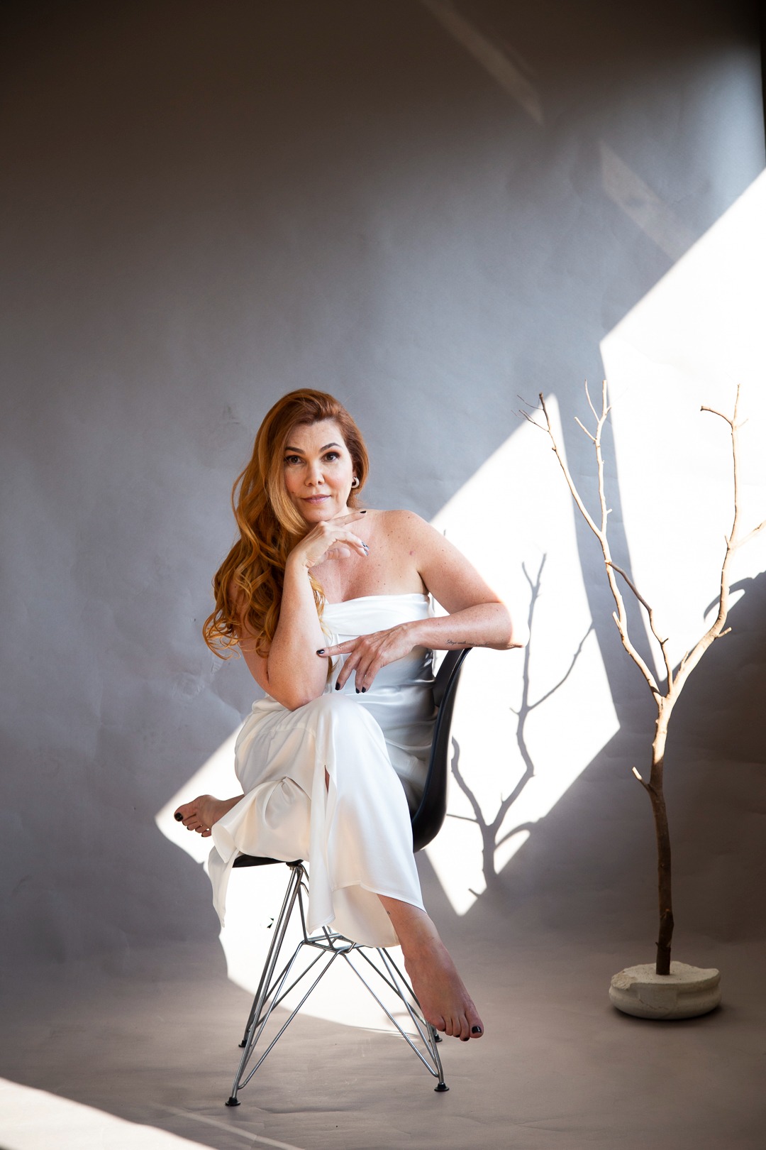 a woman in a white dress sitting in a chair