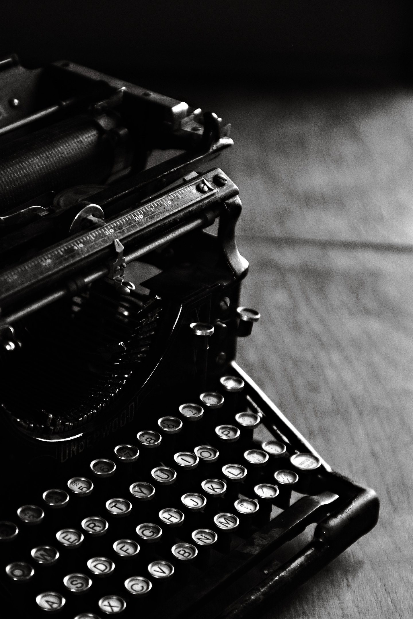 A vintage Underwood typewriter in black and white featuring classic round keys on a wooden desk.