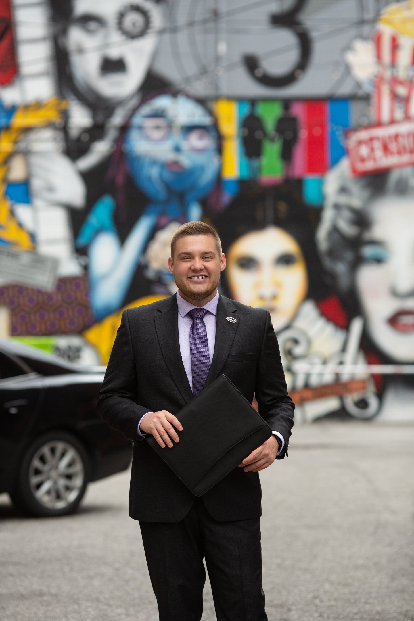 A man standing with a binder