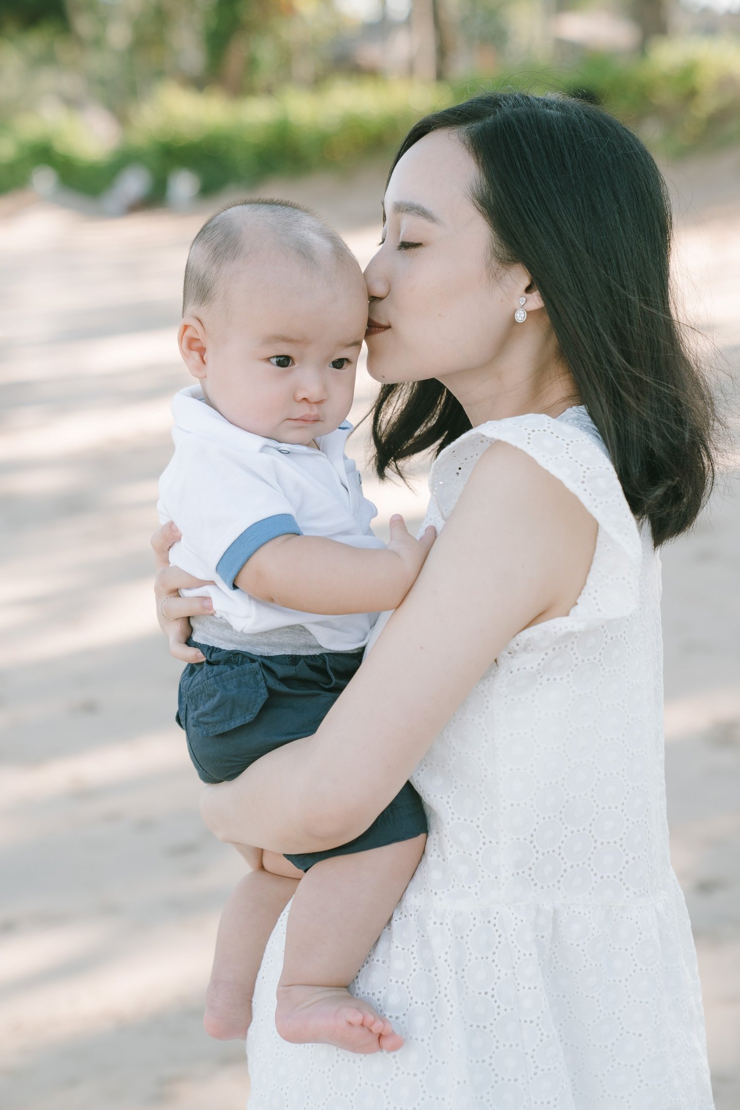 Mother holding baby outdoors at Intercontinental Jimbaran during a calm and natural Bali family photography session