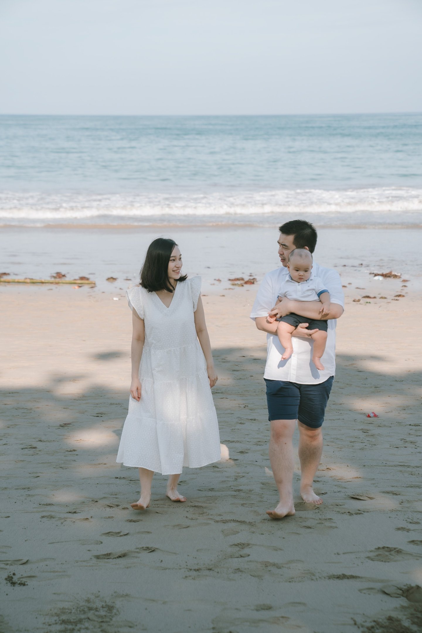 Family walking along the beach at Intercontinental Jimbaran during a calm and natural Bali family photography session