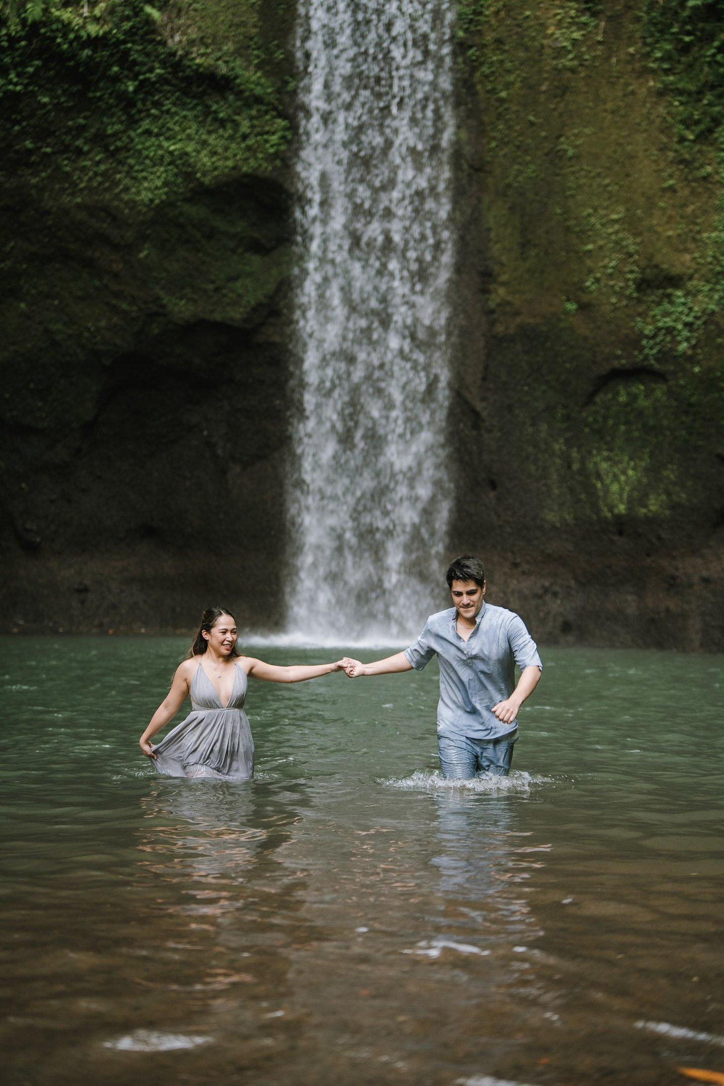 Prewedding couple standing in river at Tibumana Waterfall Bangli Bali