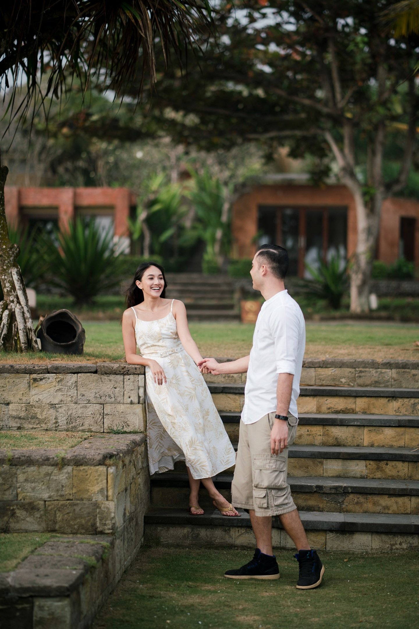 Intimate couple interacting on garden steps at Waka Gangga luxury resort in Tabanan Bali