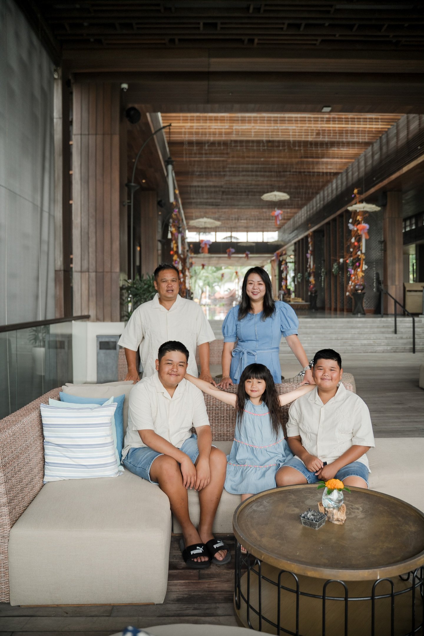 family photography session indoors at Movenpick Jimbaran Bali with parents and children sitting together in a relaxed setting