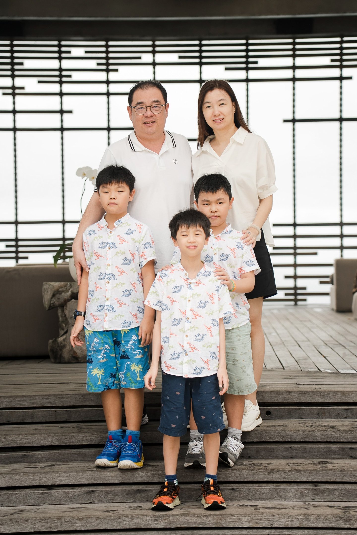 Family portrait on wooden deck at Alila Villas Uluwatu Bali with relaxed natural expressions