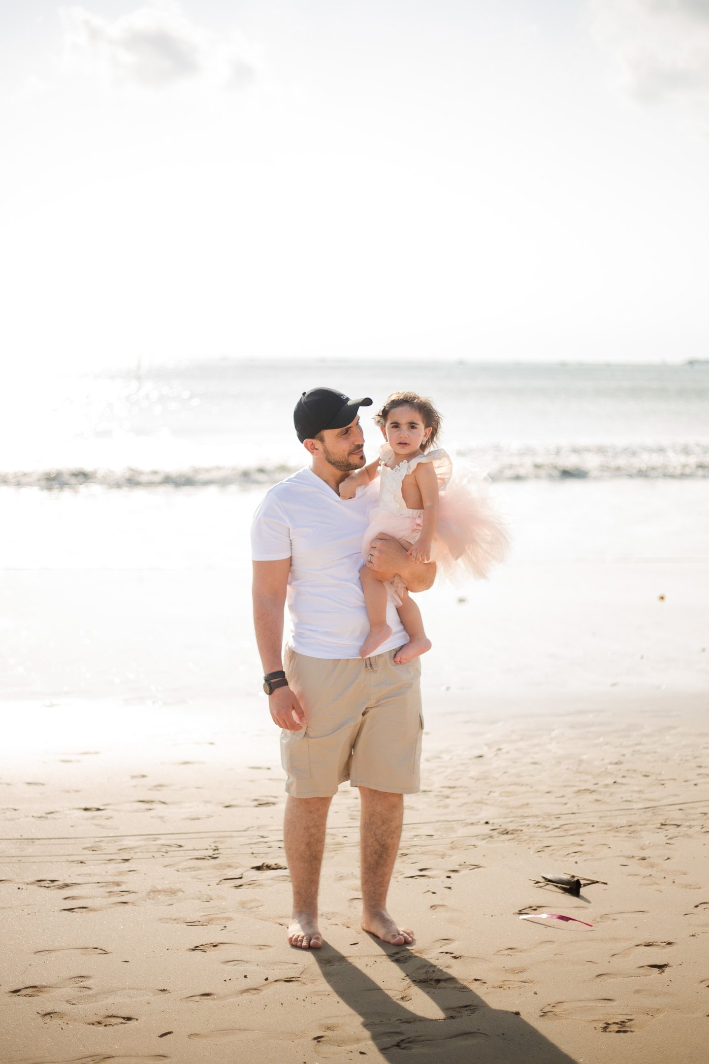 family photography Jimbaran Beach Bali mother father and child close moment by ocean