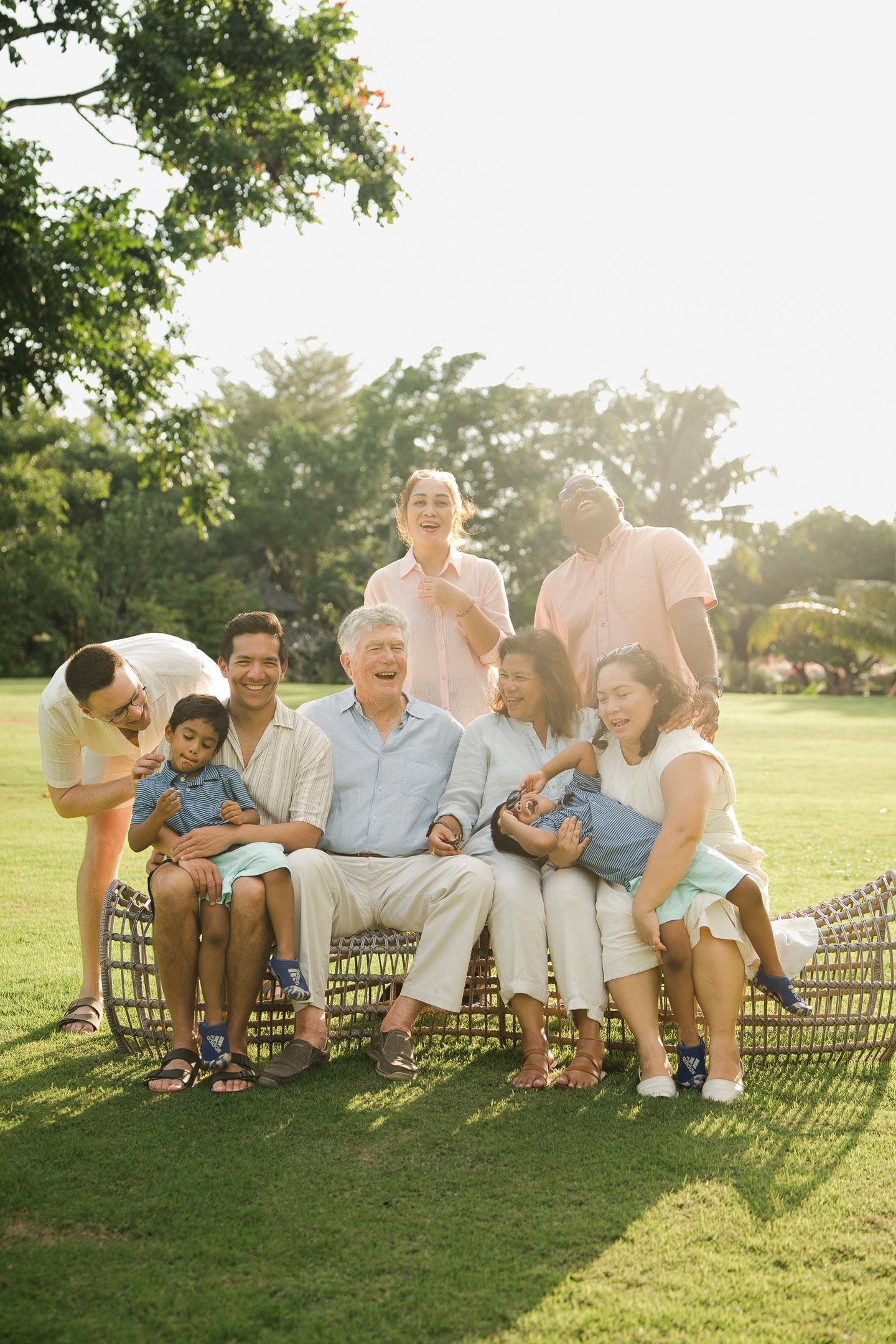 extended family relaxing together on rattan lounge chairs at rimba by ayana bali during family photography
