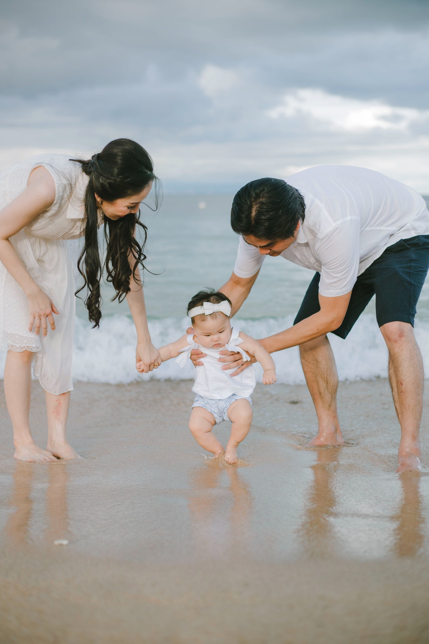 Family walking together in shallow water during Sofitel Nusa Dua Bali family photography session