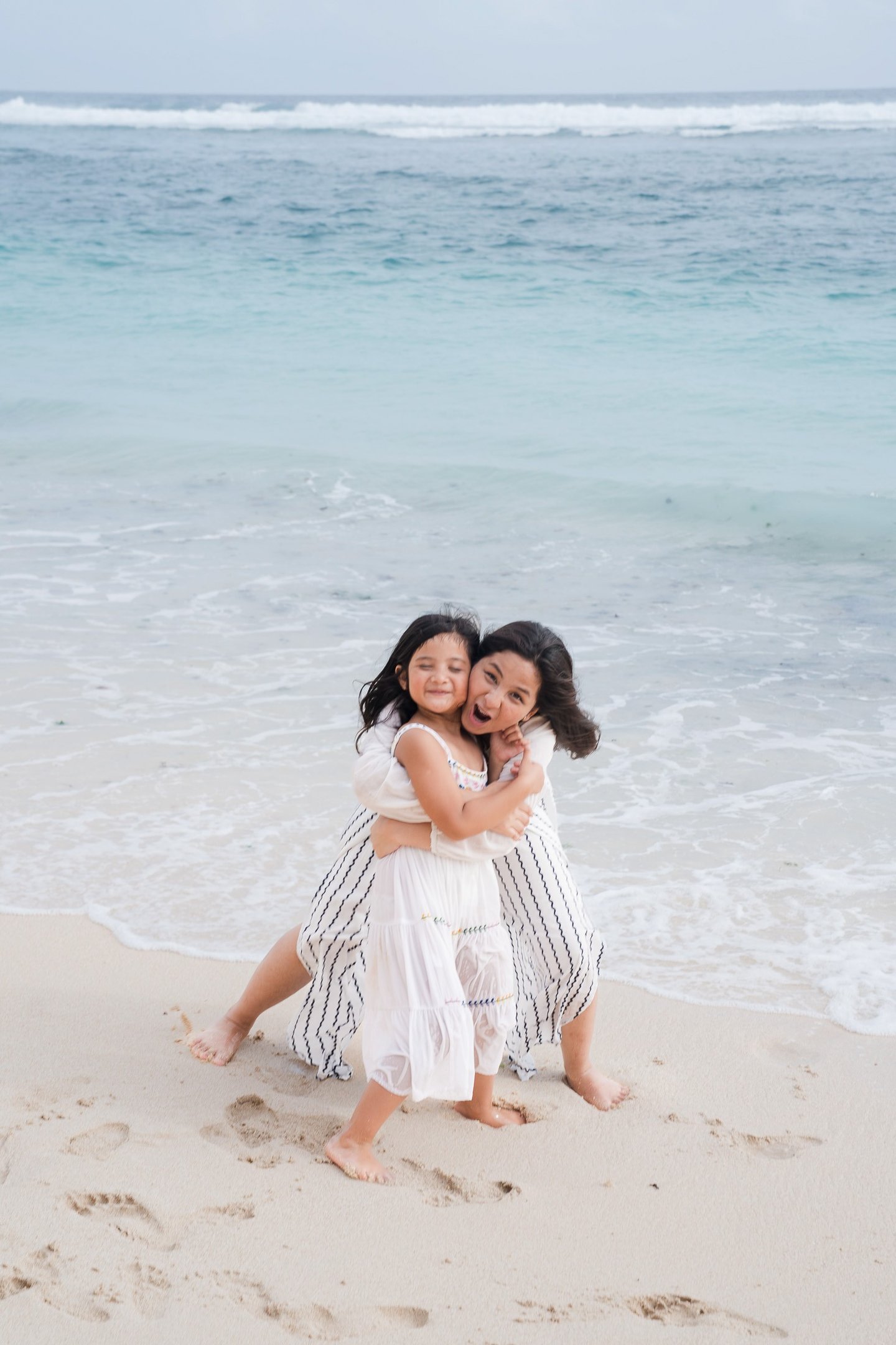 Mother hugging her children on the beach at Karma Kandara Bali  