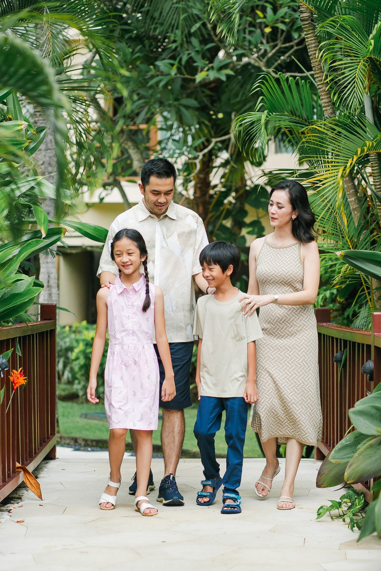 family walking together during photography session at Westin Nusa Dua Bali tropical garden path
