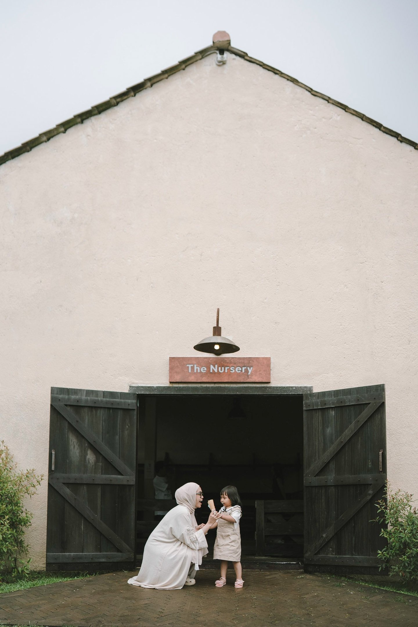 Mother and child in front of nursery house during a family photography session at Bali Farm House Bedugul Bali.