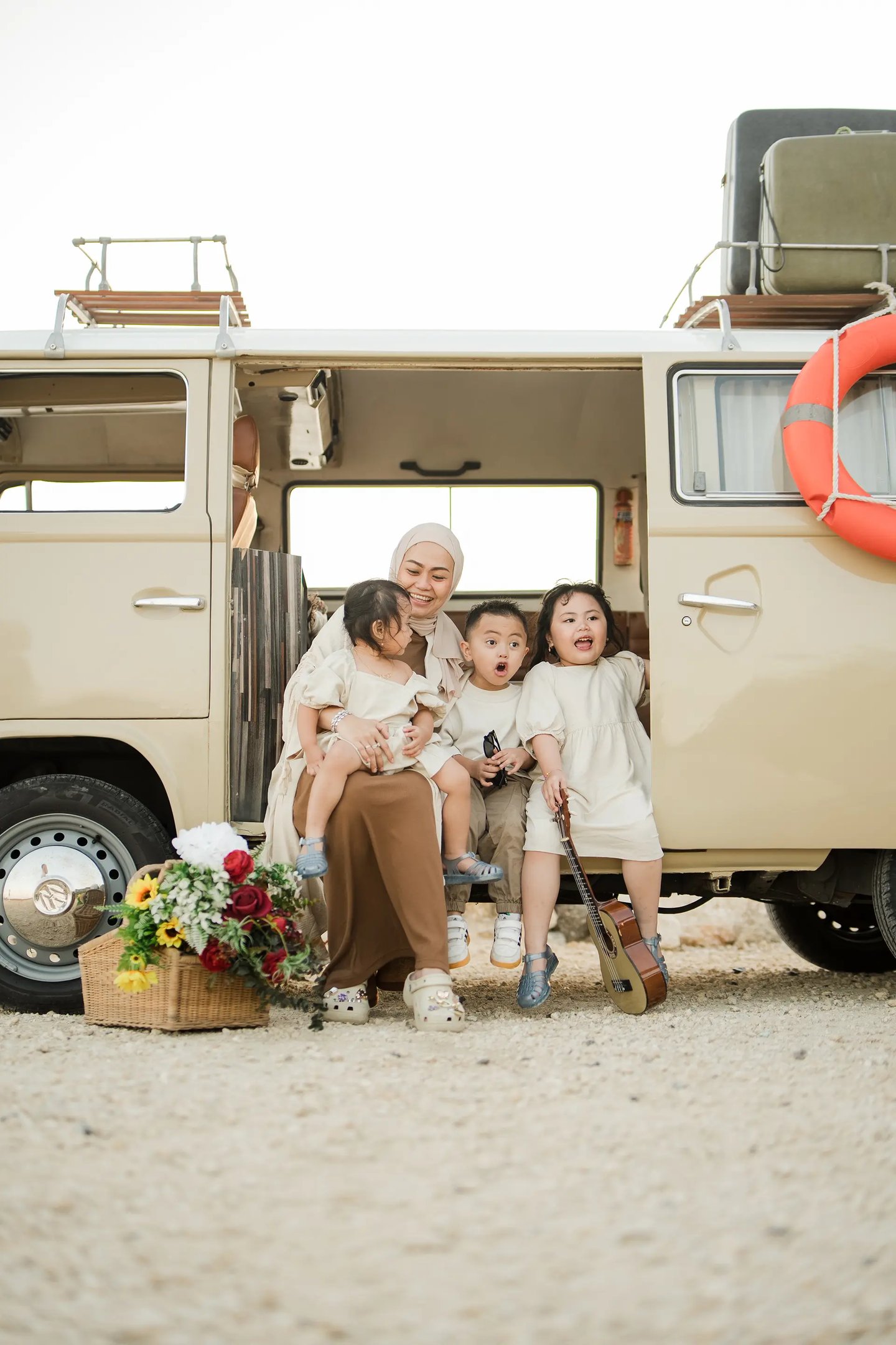 Ilham family portrait beside a vintage retro combi van at Melasti Beach Bali
