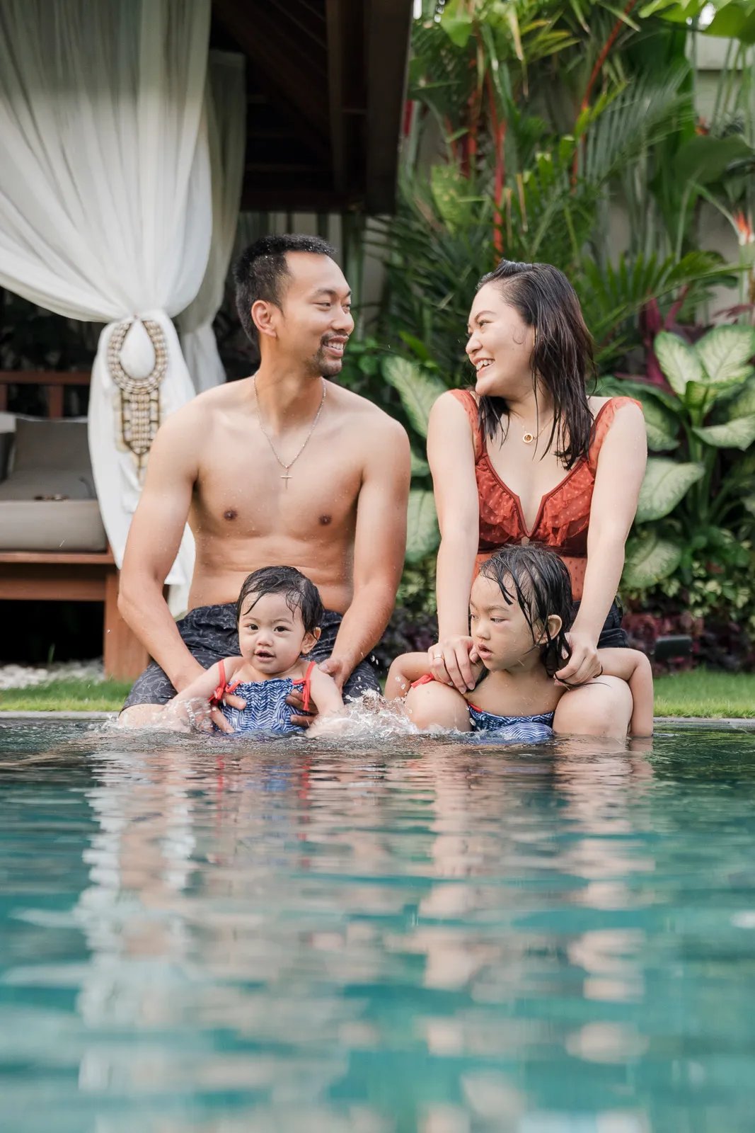 Playful family photography session by the pool at a private villa in Seminyak Bali with relaxed tropical lifestyle moments.