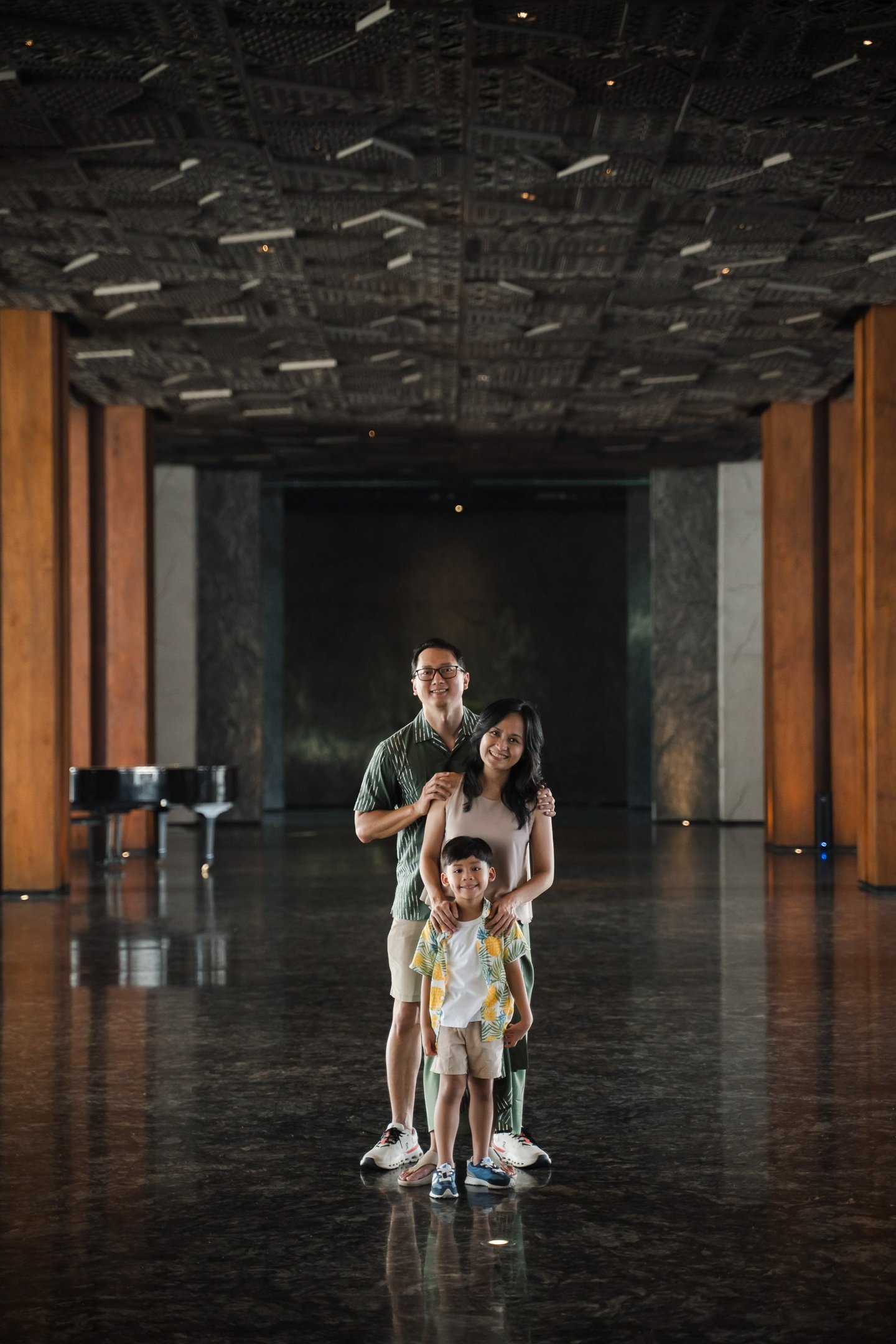 Family portrait standing inside modern resort architecture at The Meru Sanur Bali family photography