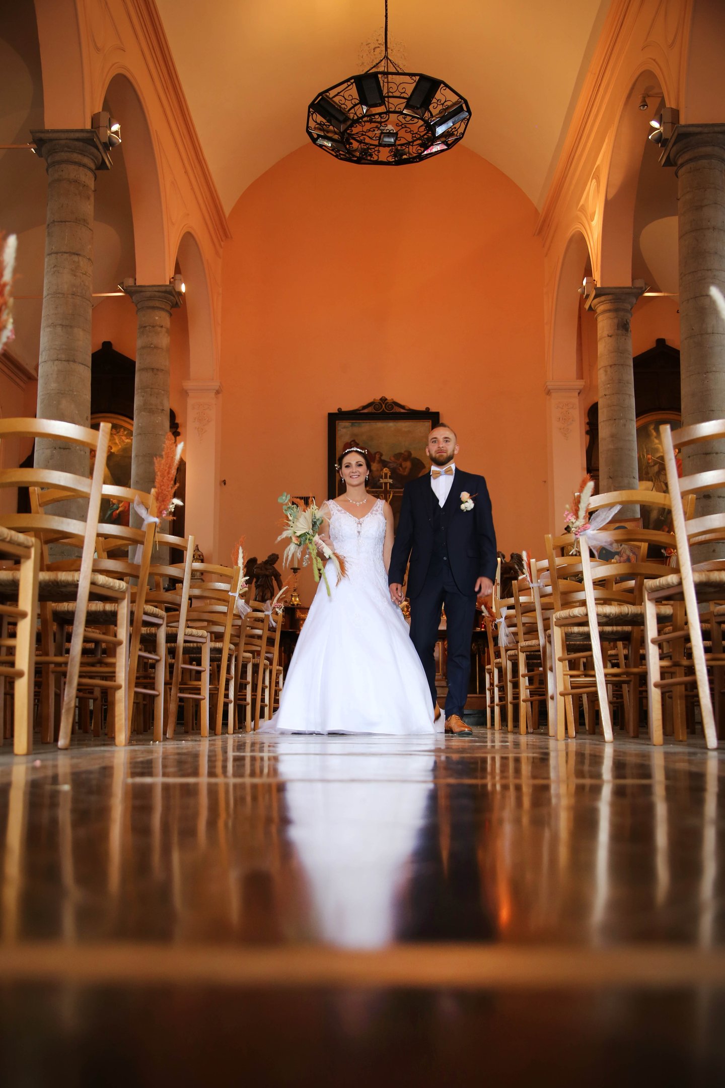 a bride and groom walking down the aisle of a church