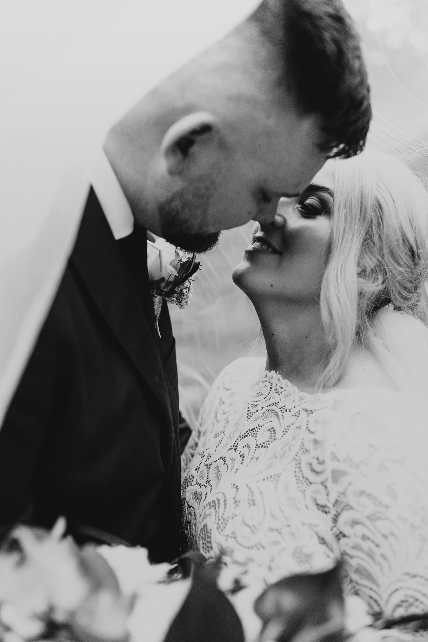 a bride and groom kissing in a black and white photo