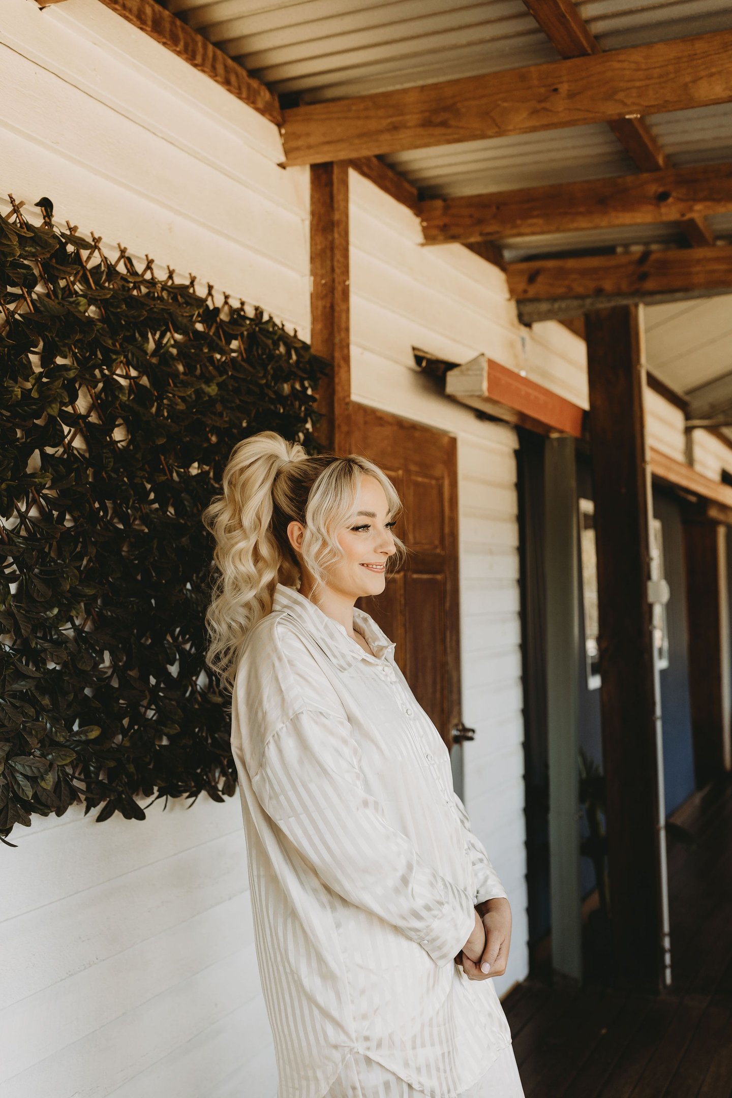 a woman standing in front of a wall with a planter
