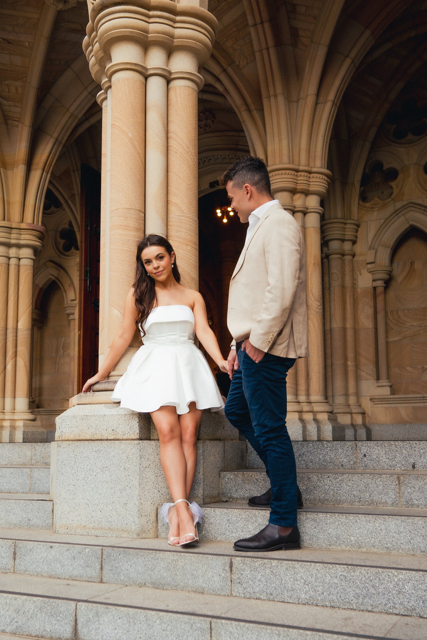 a man and woman standing on stairs in front of a building