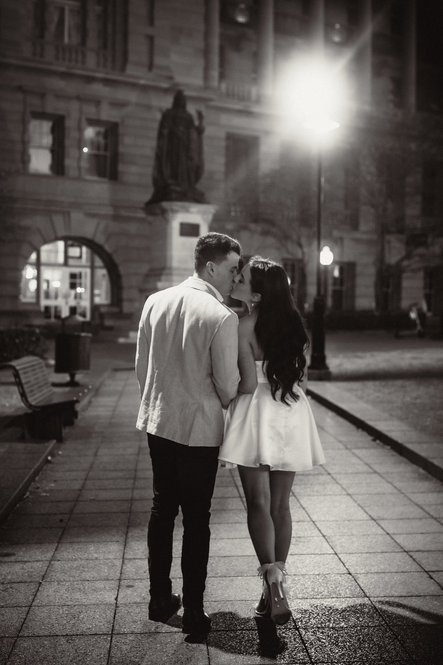 a couple kissing in a city street at night