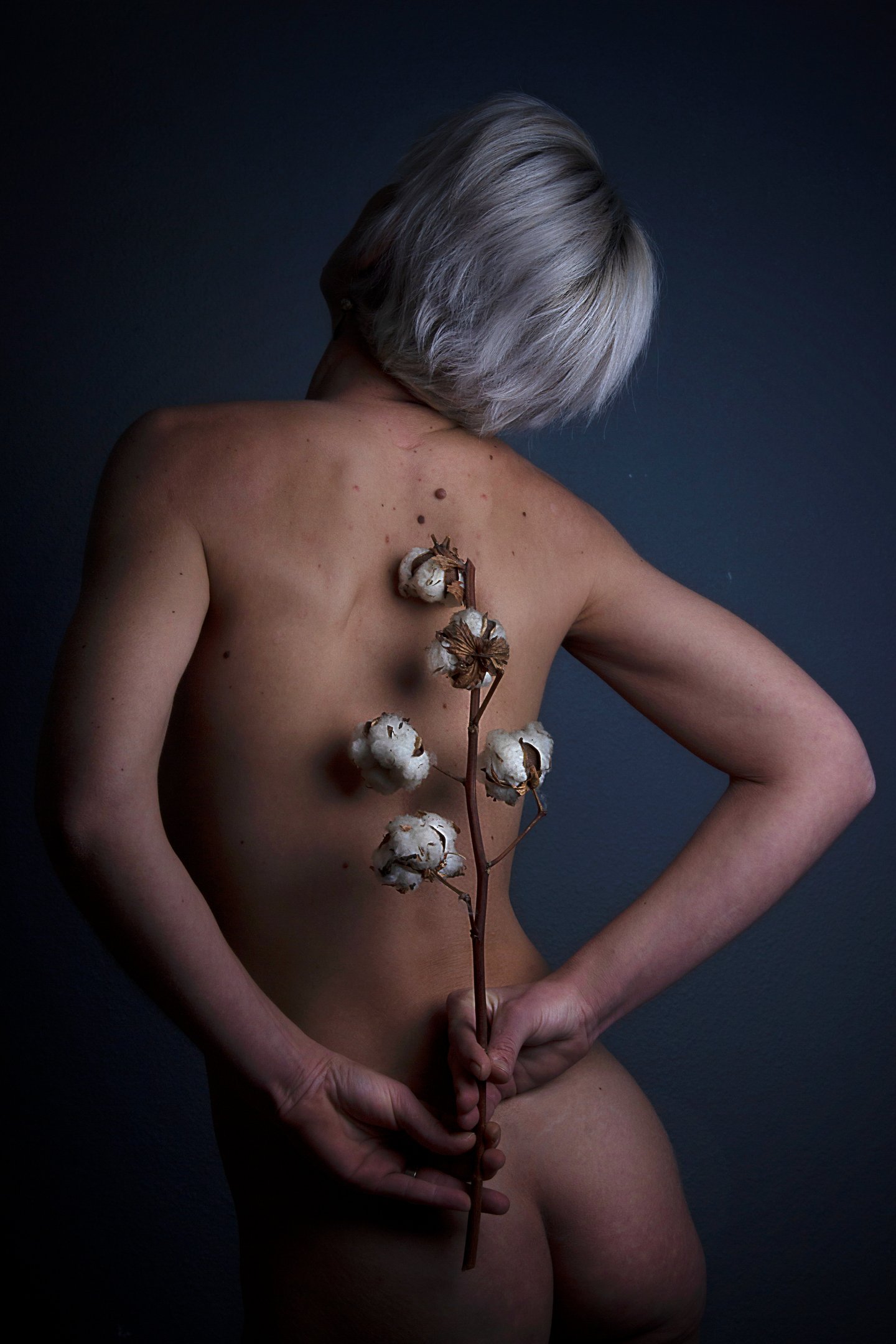 main qui tiennent une fleur sur un dos nu