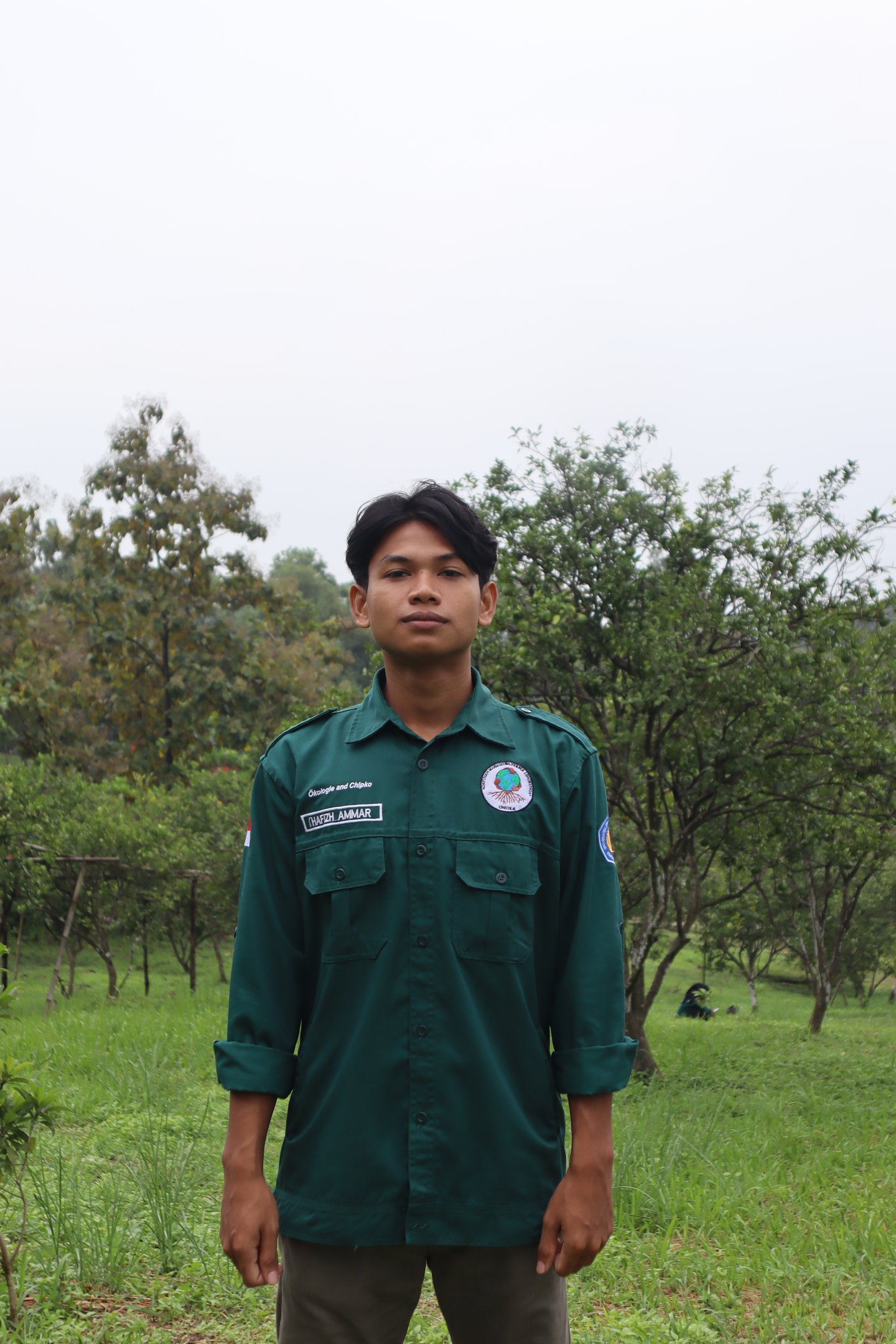 a man in a green uniform standing in a field