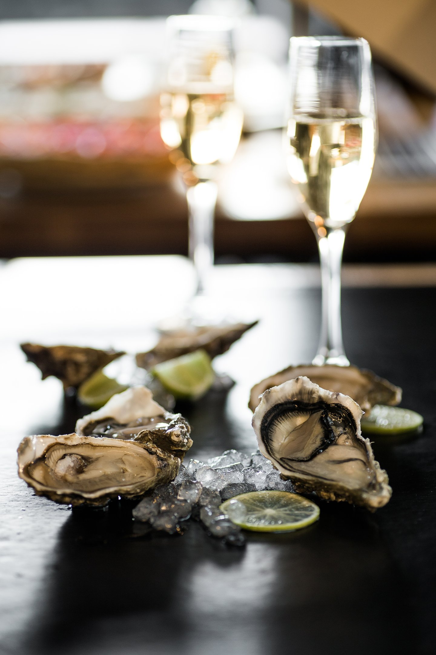 Huîtres ouvertes posées à côté de deux flûtes de Champagne