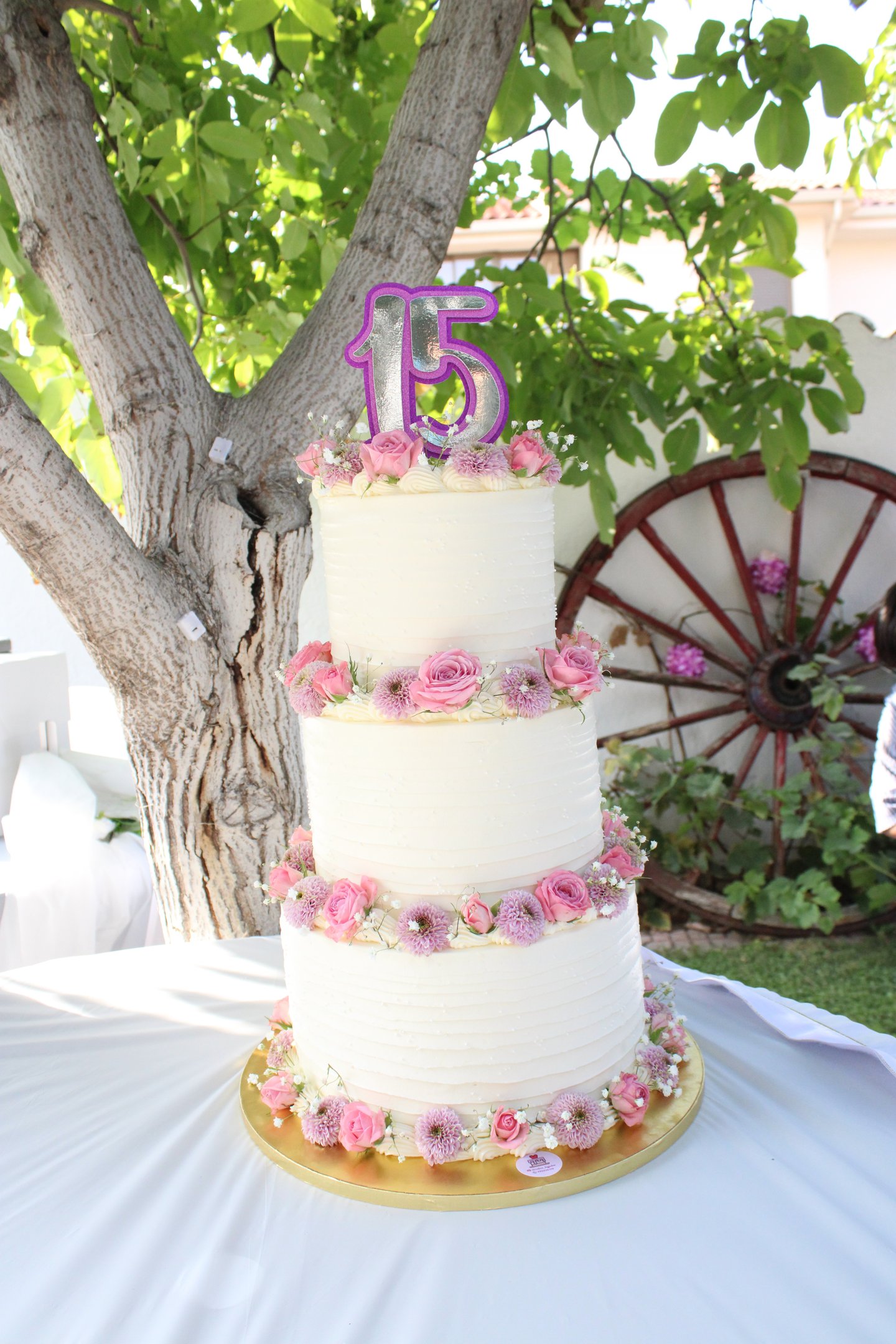 Tarta de cumpleaños elegante con flores naturales en tonos rosas, creada en Madrid