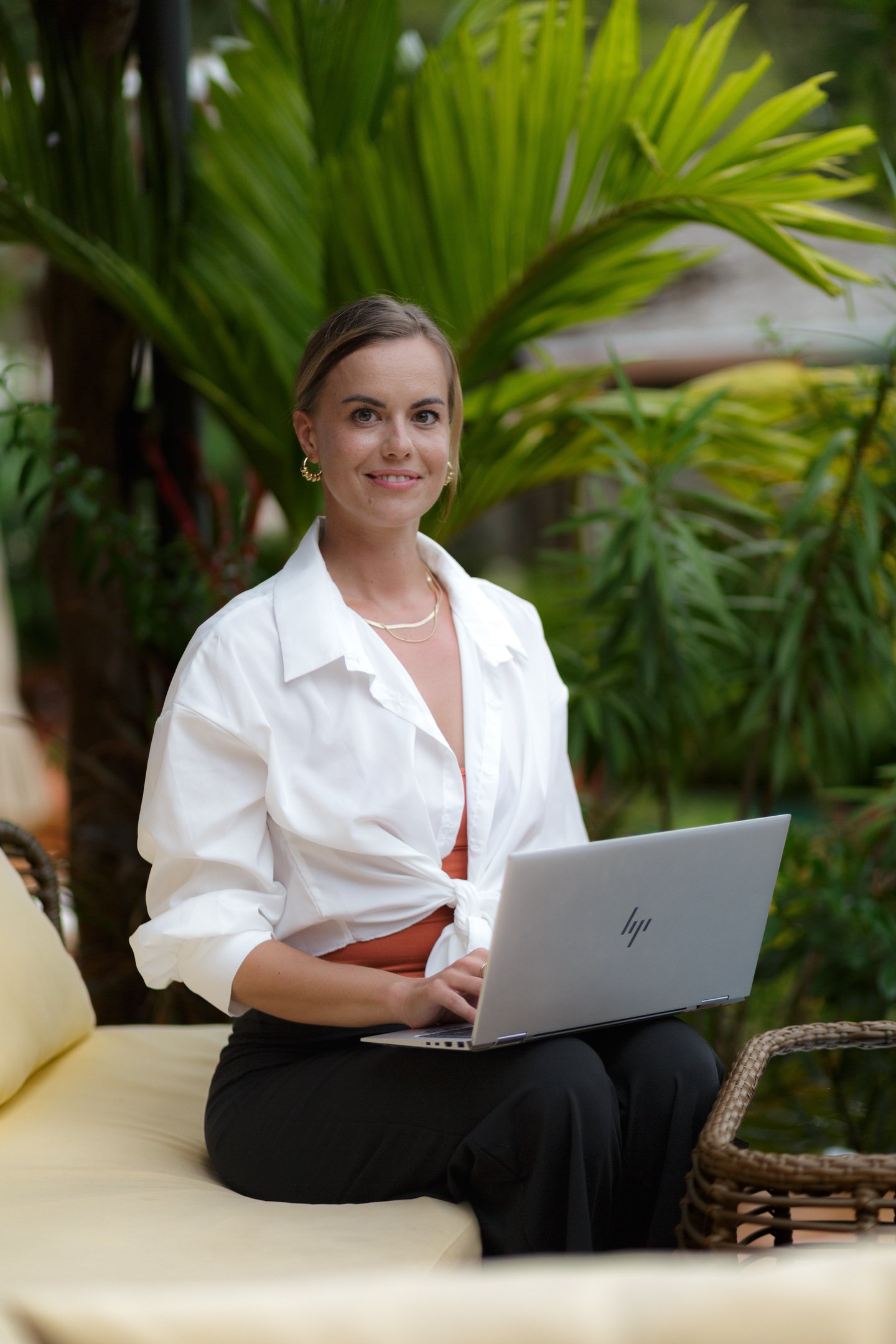 portrait of Eni. woman with a background of plants in nature working with a laptop
