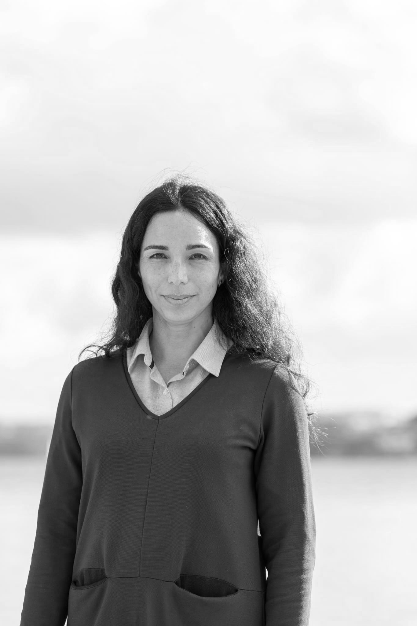 una mujer sonriendo y mirando a la cámara en foto blanco y negro