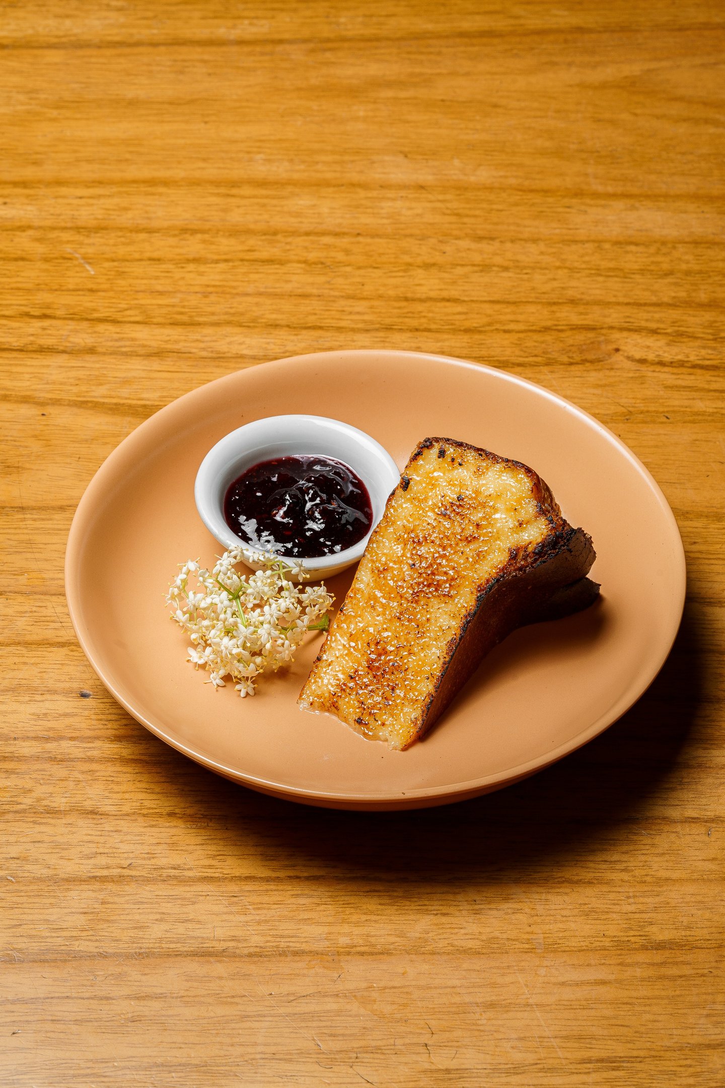 a plate of a slice of cheesecake and a bowl of jam