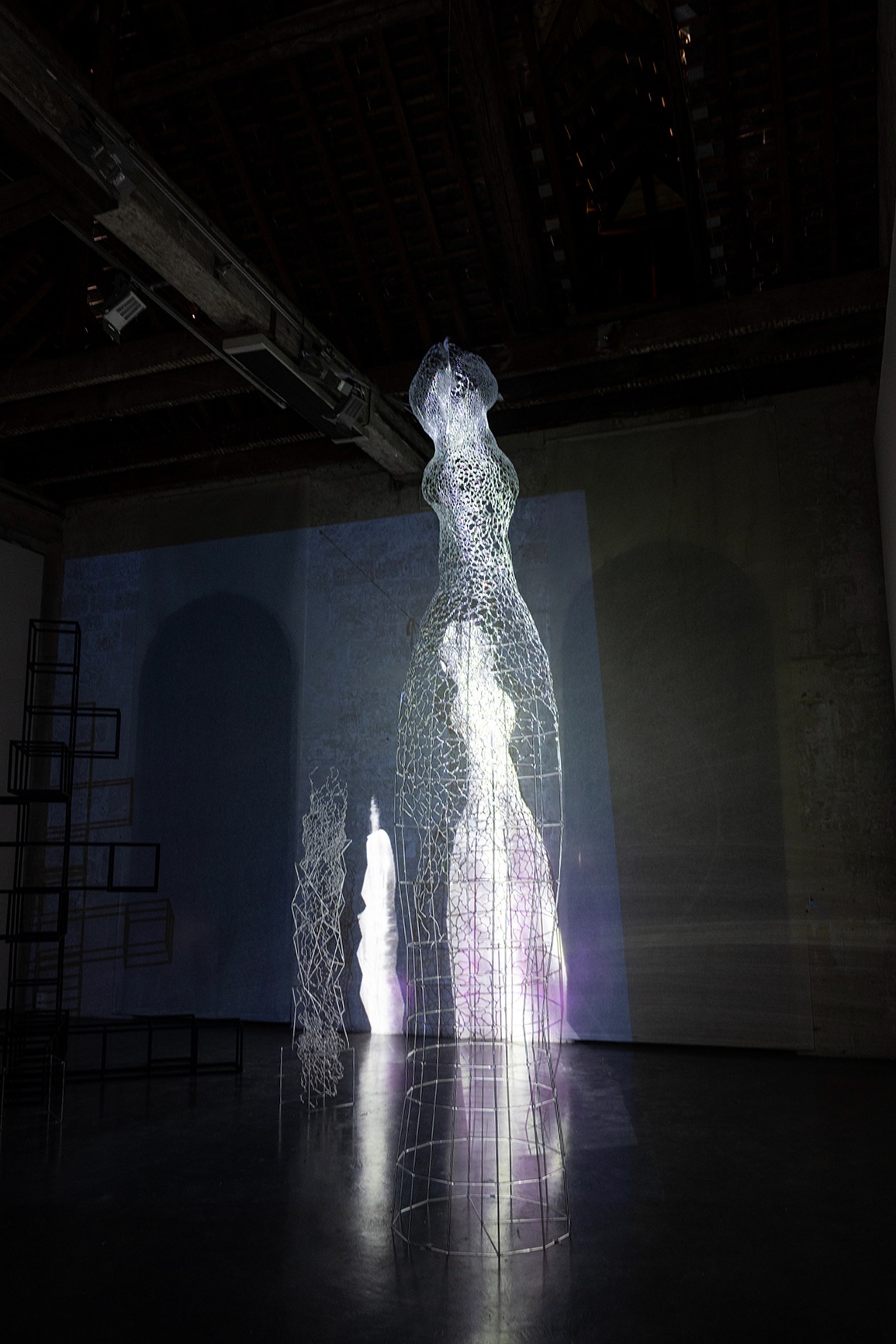 Video mapping on a large glass sculpture representing an human form