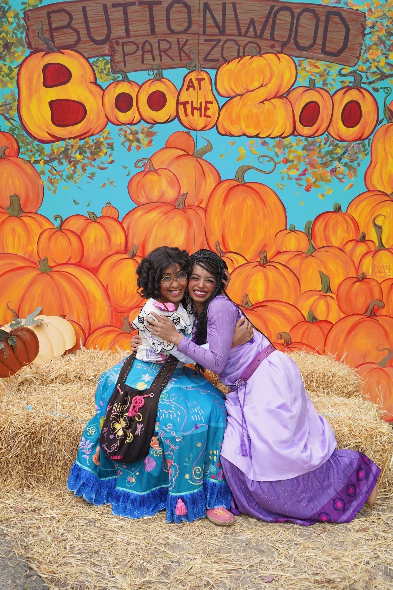 Mirabel and Asha hug for a photo at a fall festival