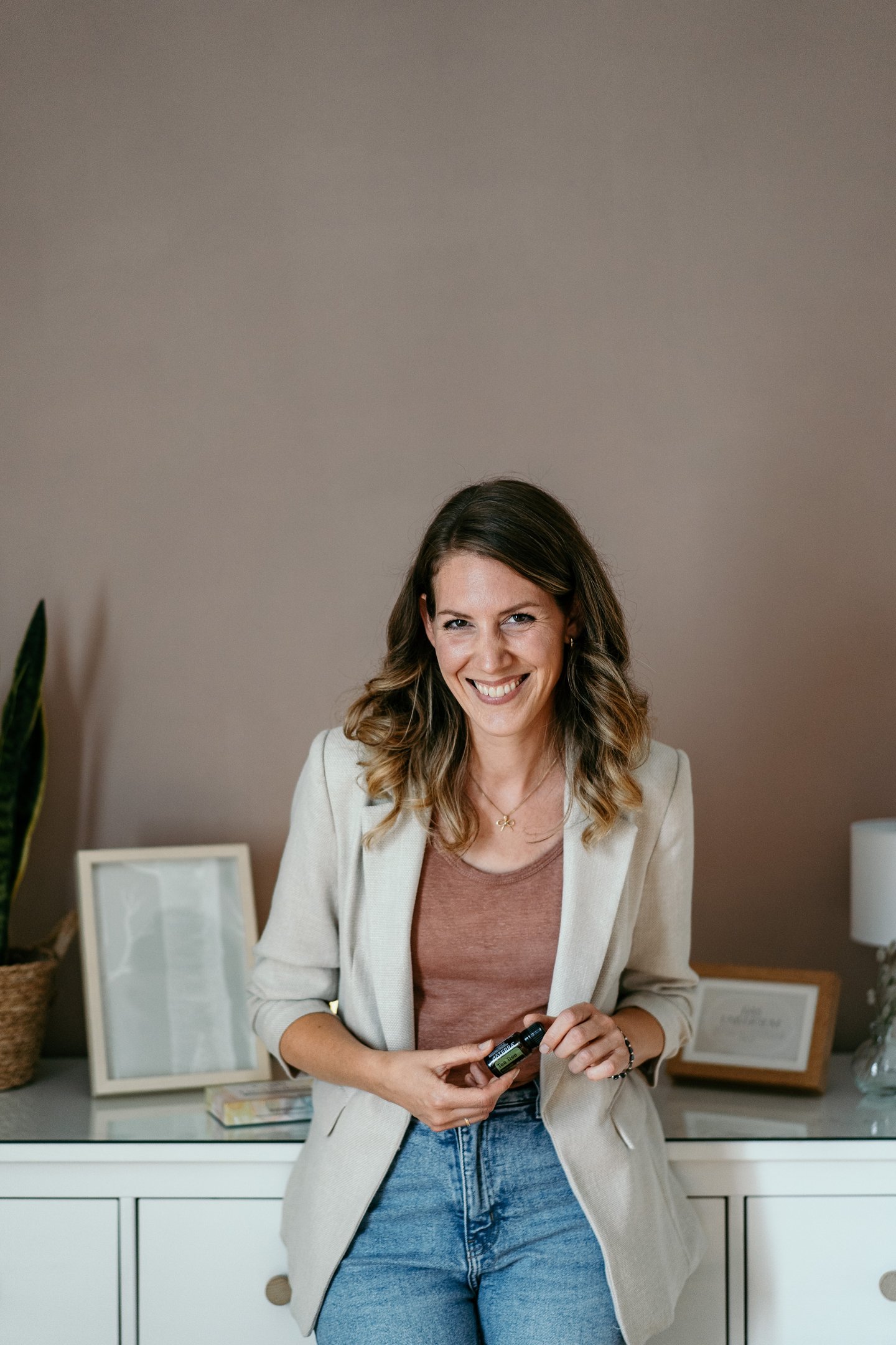 dōTERRA Wellnessbotschafterin hält ätherisches Öl in der Hand familienfreundliches Business