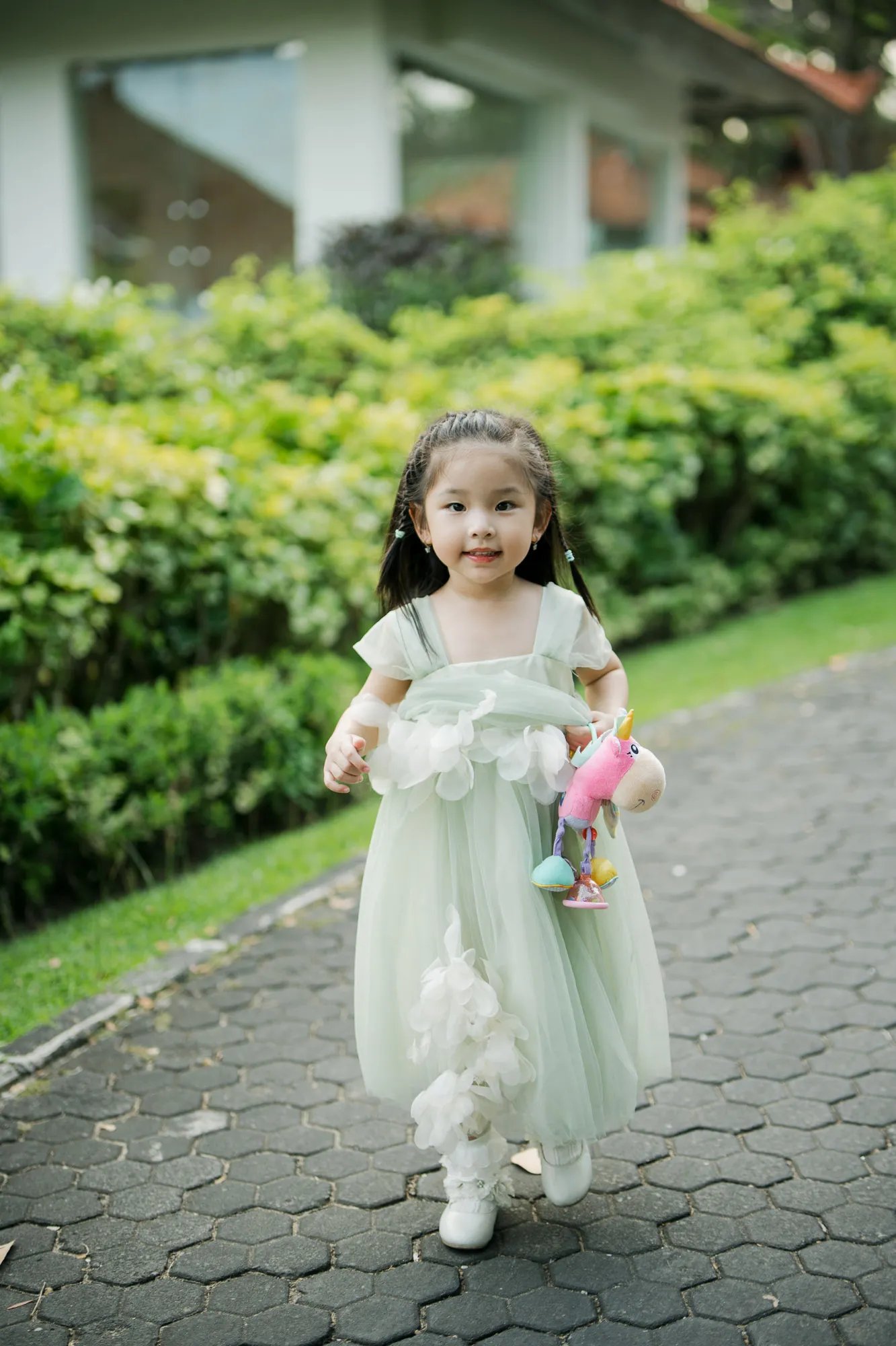 Young girl walking through a tropical resort garden during a family photography session in Bali.