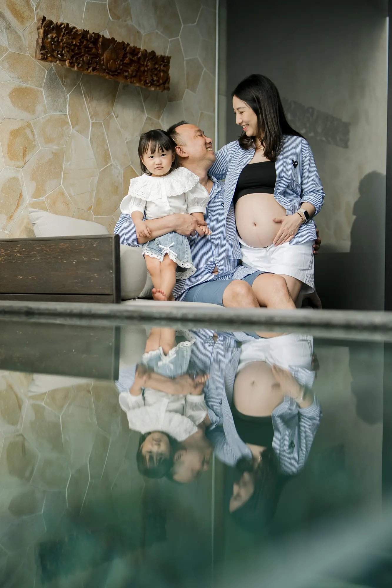 Family babymoon photography with parents and daughter inside a luxury suite at The Apurva Kempinski Bali