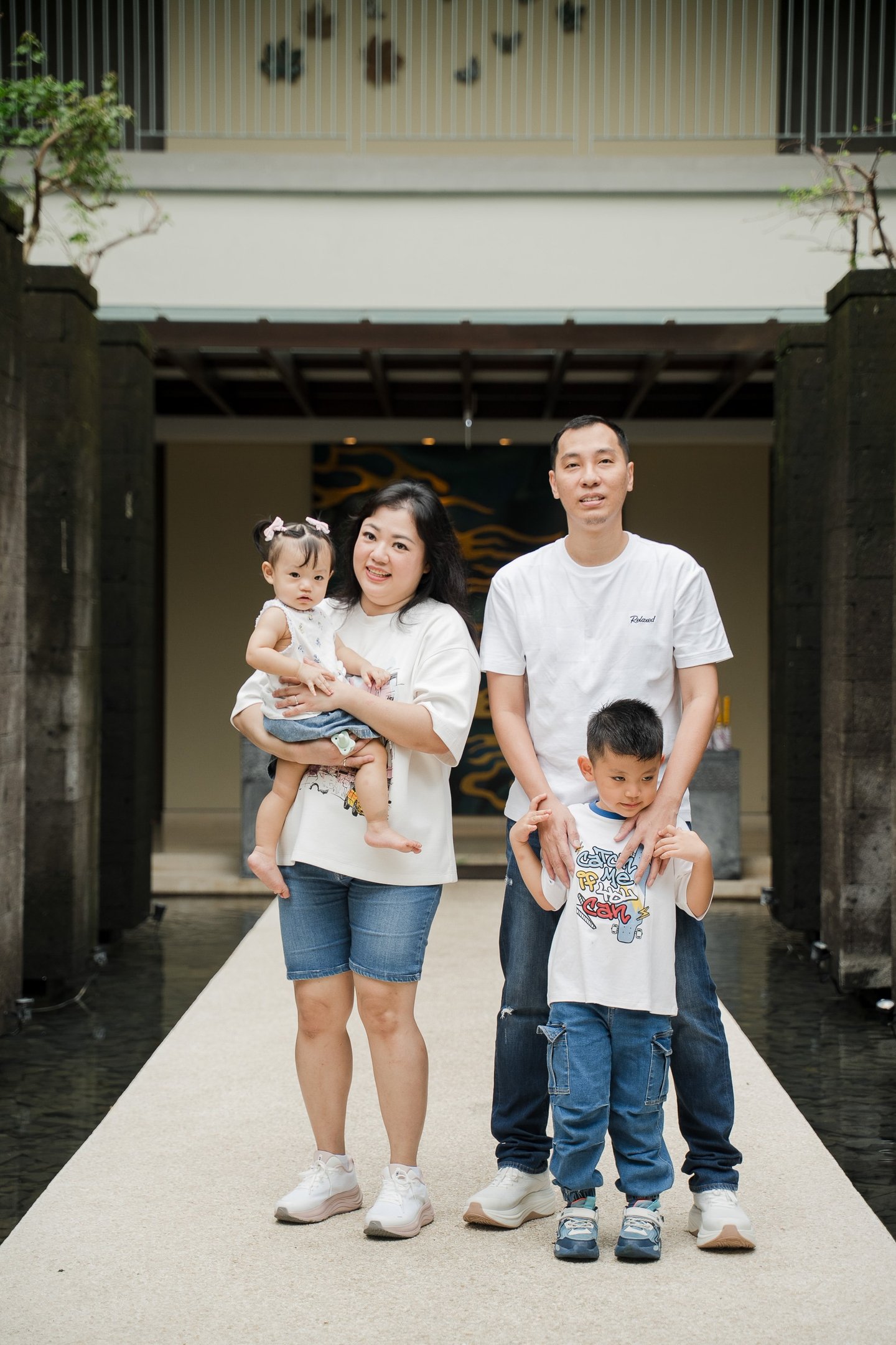 family walking together through resort entrance during a natural family photography session at Movenpick Jimbaran Bali
