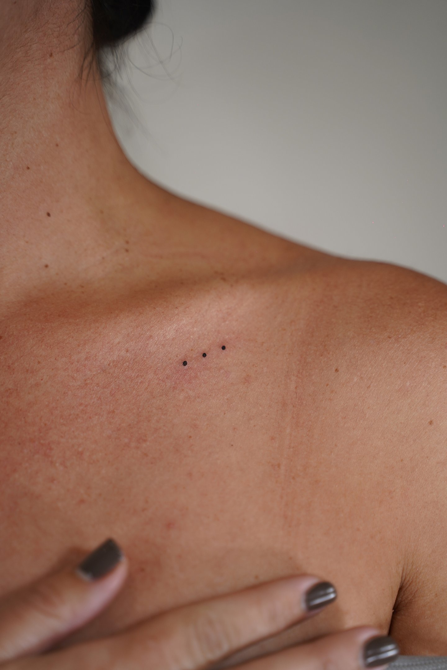 Tatuaje fineline en Madrid de tres puntos micro alineados en tinta negra en la clavícula