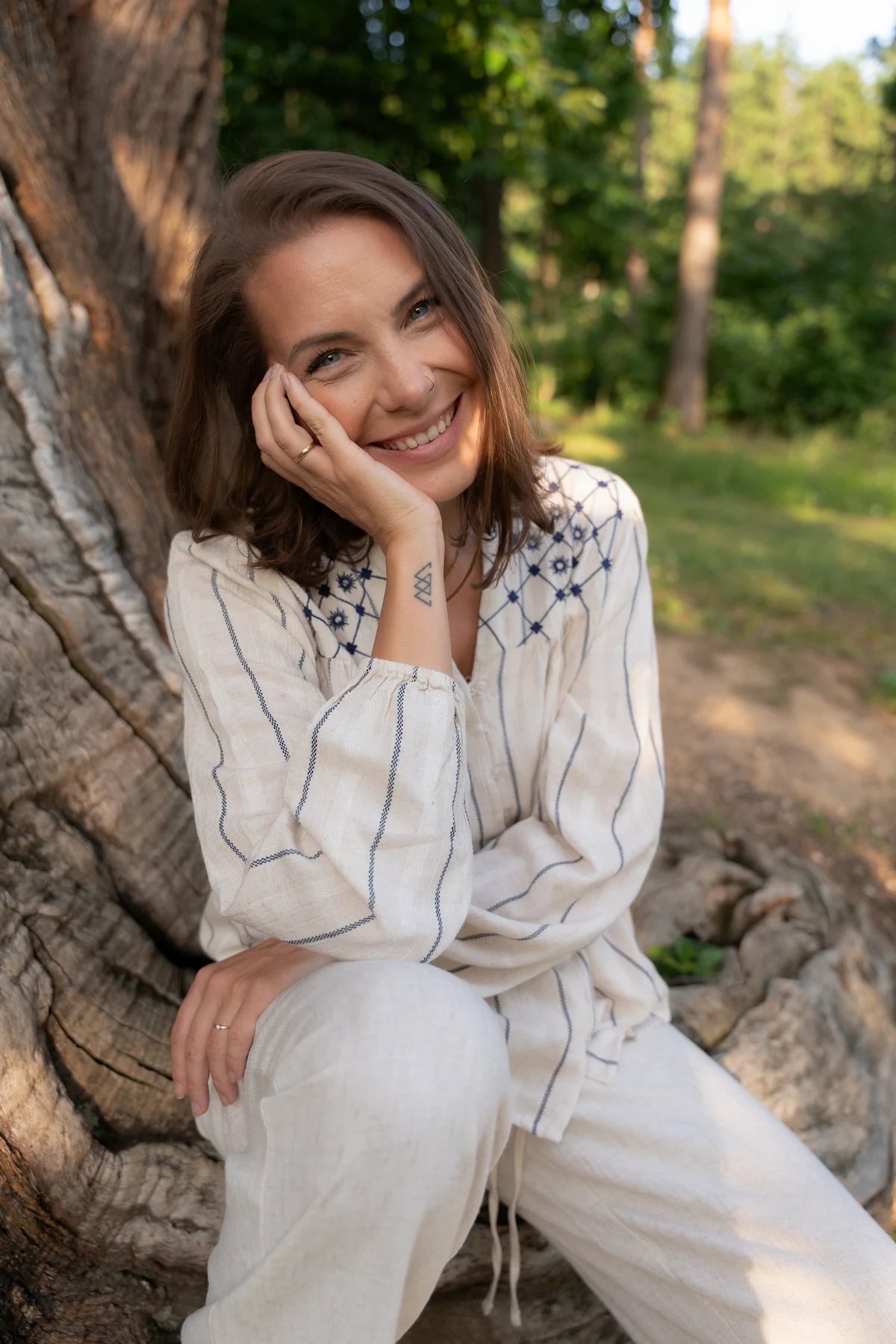 Carina Schwarz, Mentorin und Medium, lächelt in der Natur und begleitet Menschen auf ihrem Weg der Transformation.