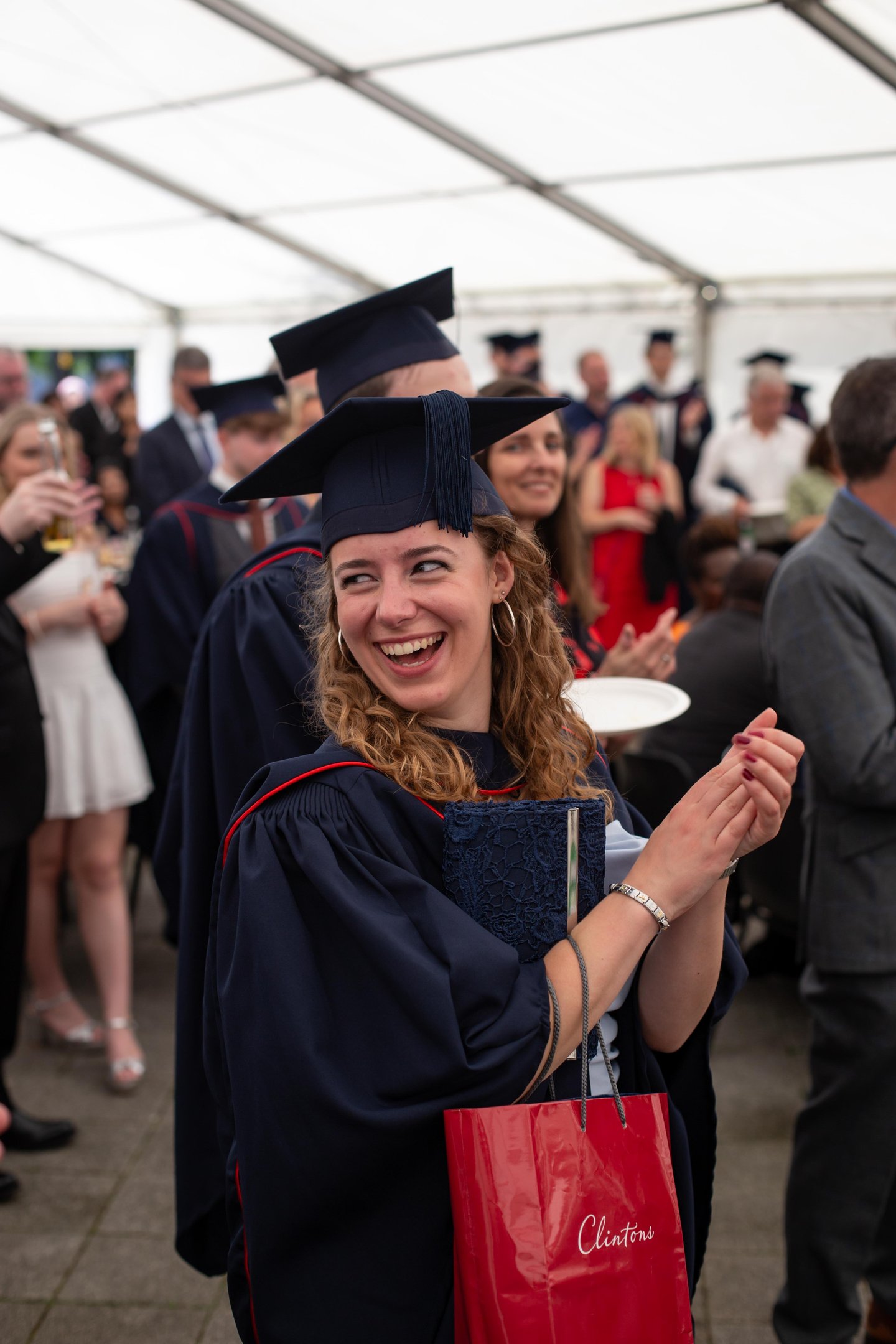 Graduation event photo of a smiling graduate in cap and gown