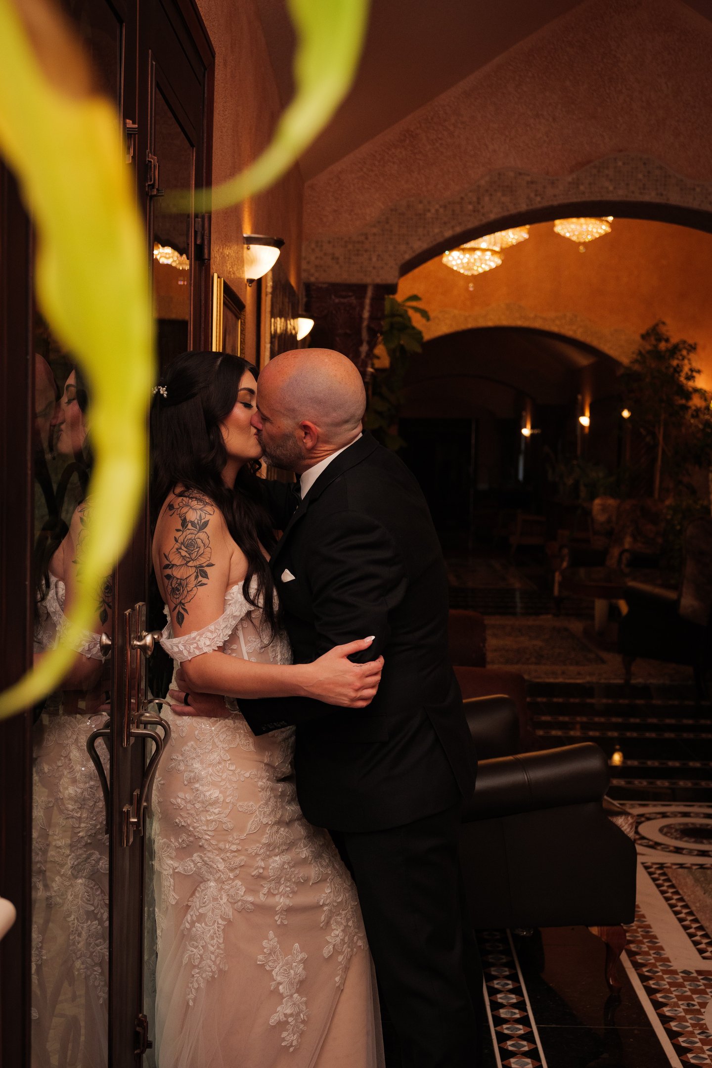 a wedding Couple kissing in a hotel lobby