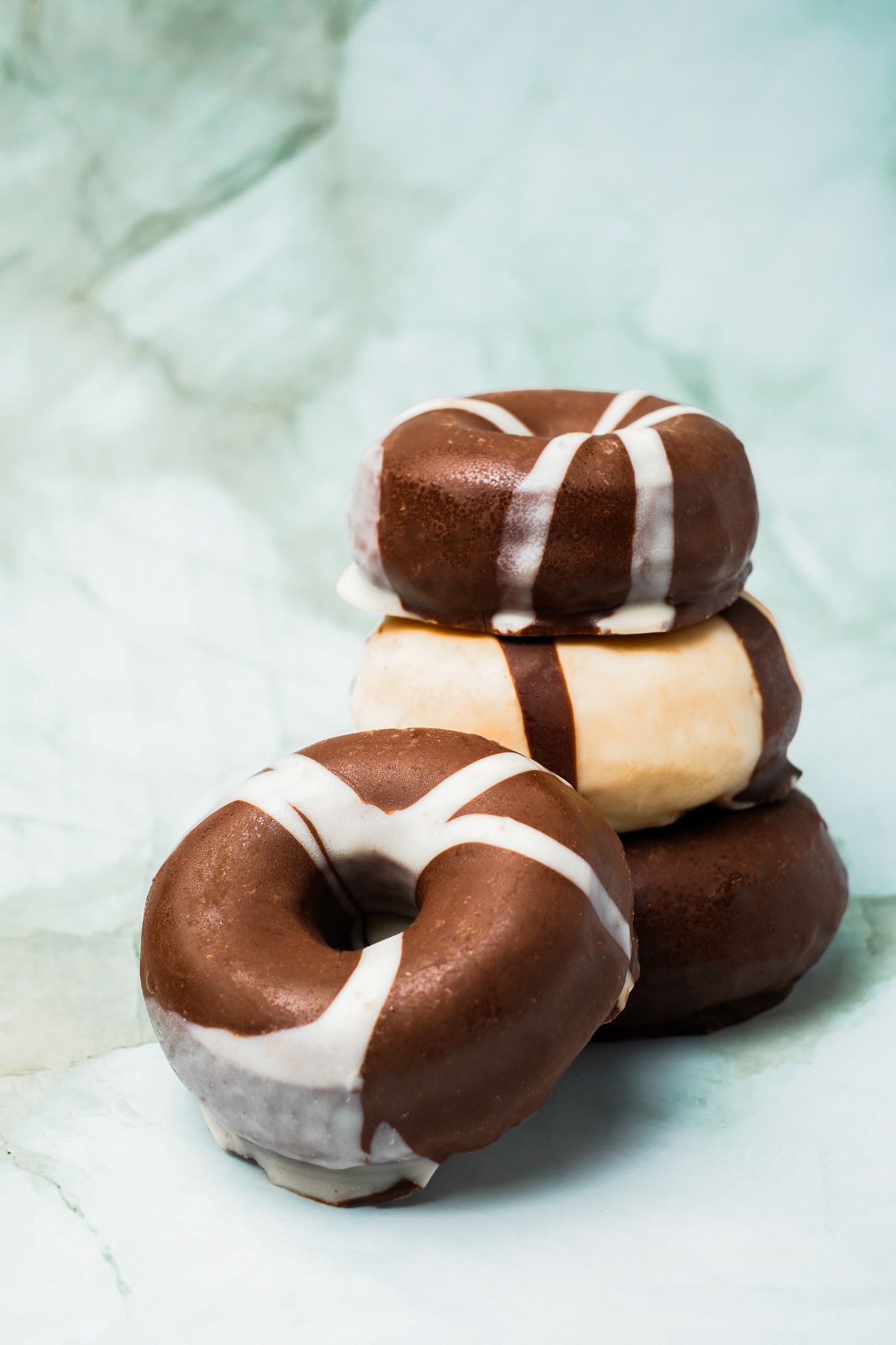 a stack of chocolate covered donuts with chocolate frosting