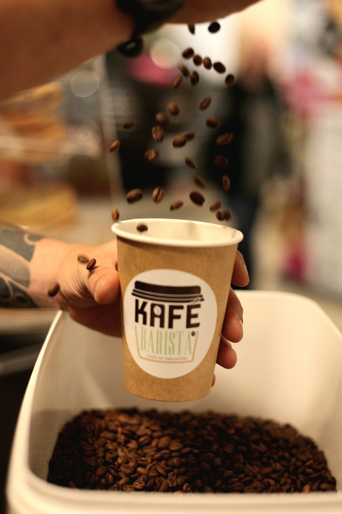 Présentation du café de spécialité Kafé Barista avec gobelet et grains de café