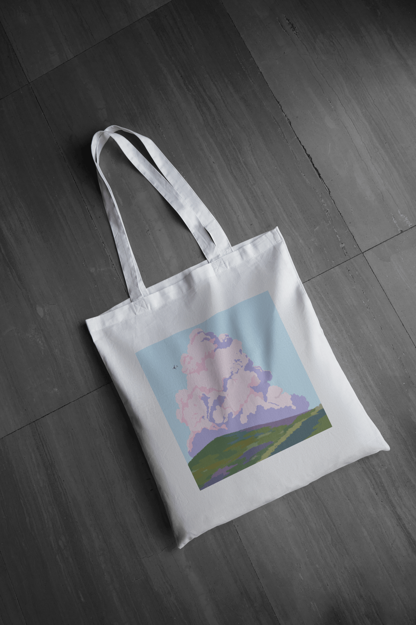 sac en toile tote bag blanc avec une image un gros nuage coloré au dessus d'un pré