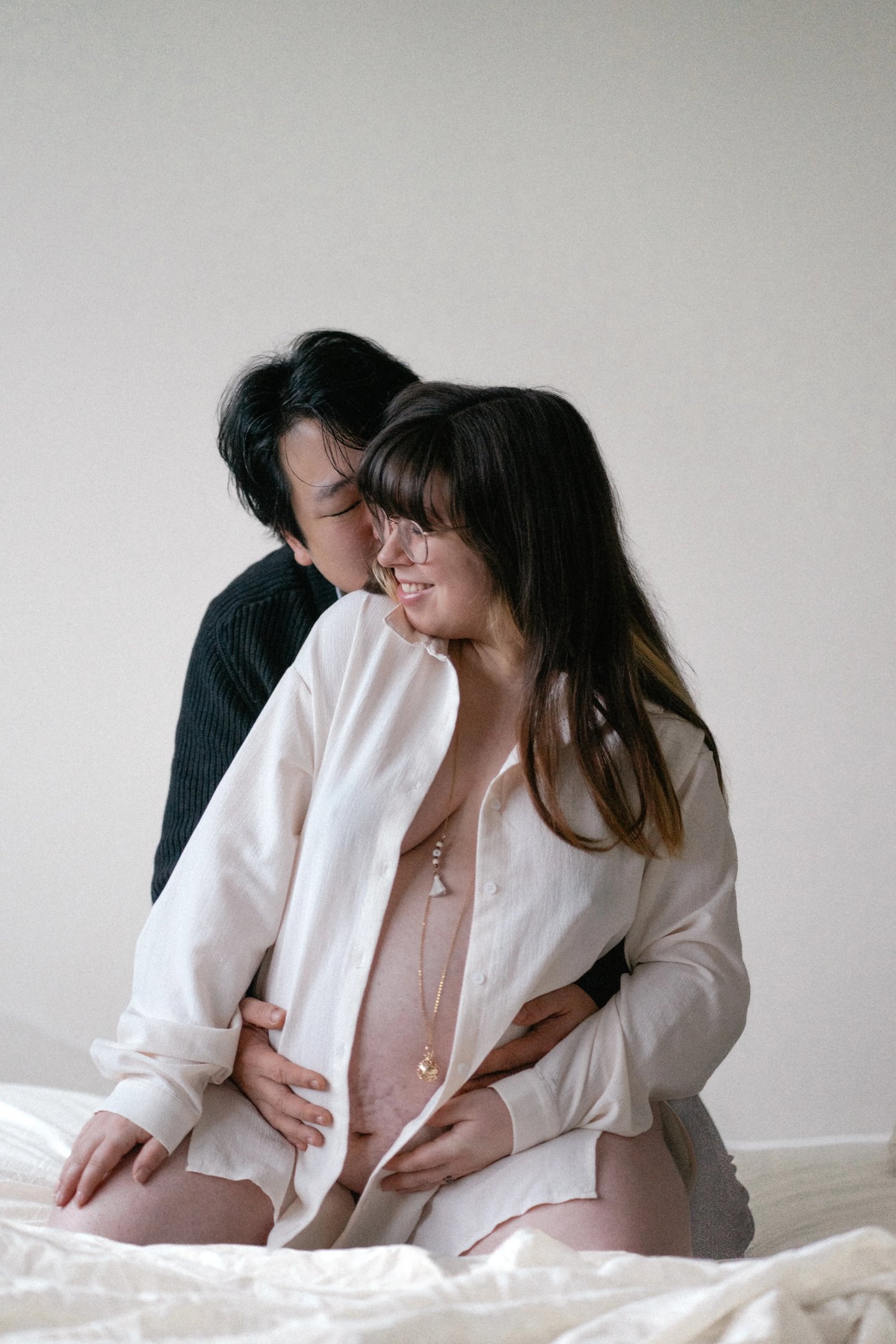 un homme et femme enceinte complice sur un lit lors d'une séance photo grossesse à Guignen, à Rennes